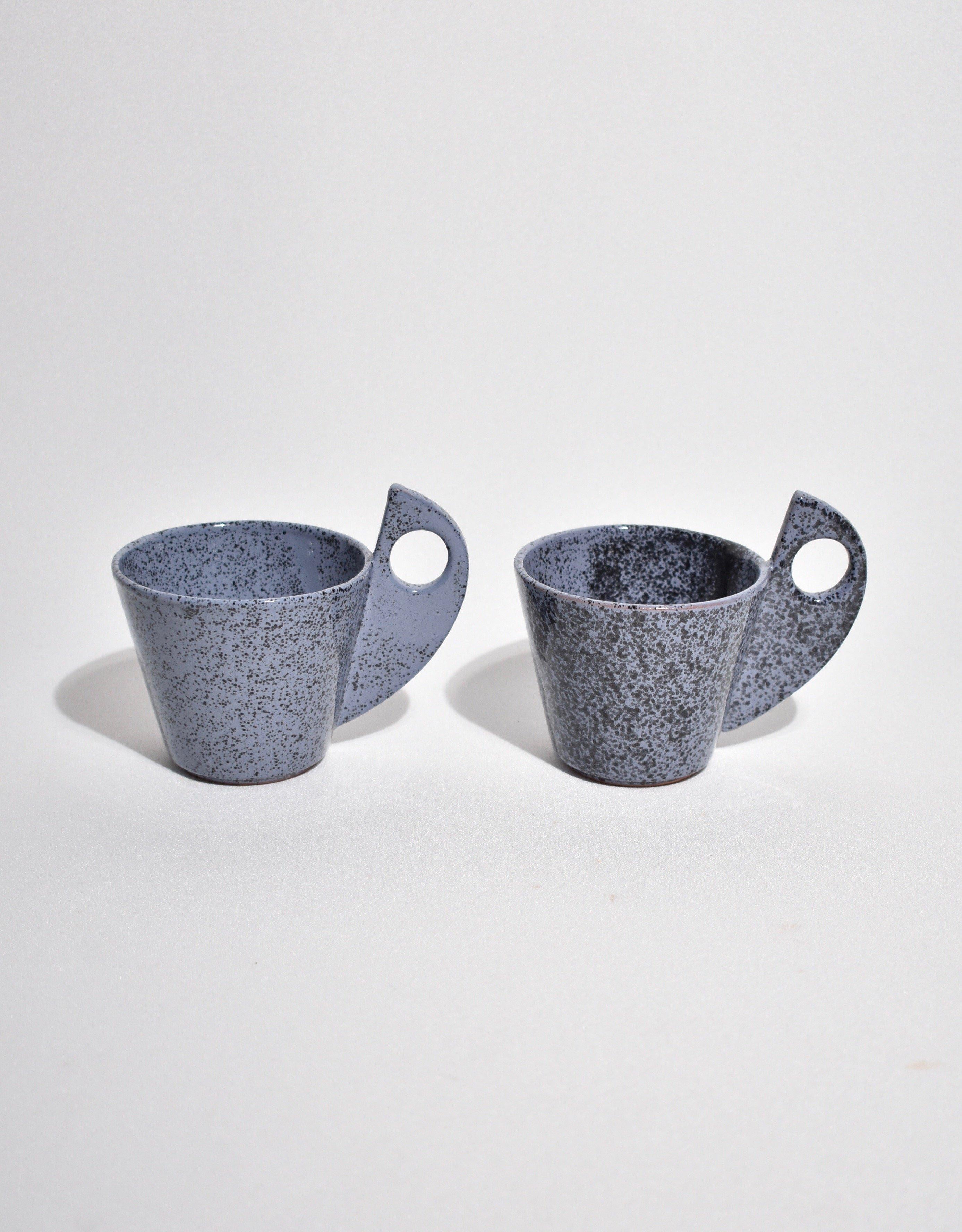 Rare, sculptural ceramic tea cup set in blue speckle pattern. Includes a set of two cups with saucers, signed. 

Dimensions:
Width: cup 4.5 in (11.43 cm) saucer 5.25 in (13.33 cm).

 