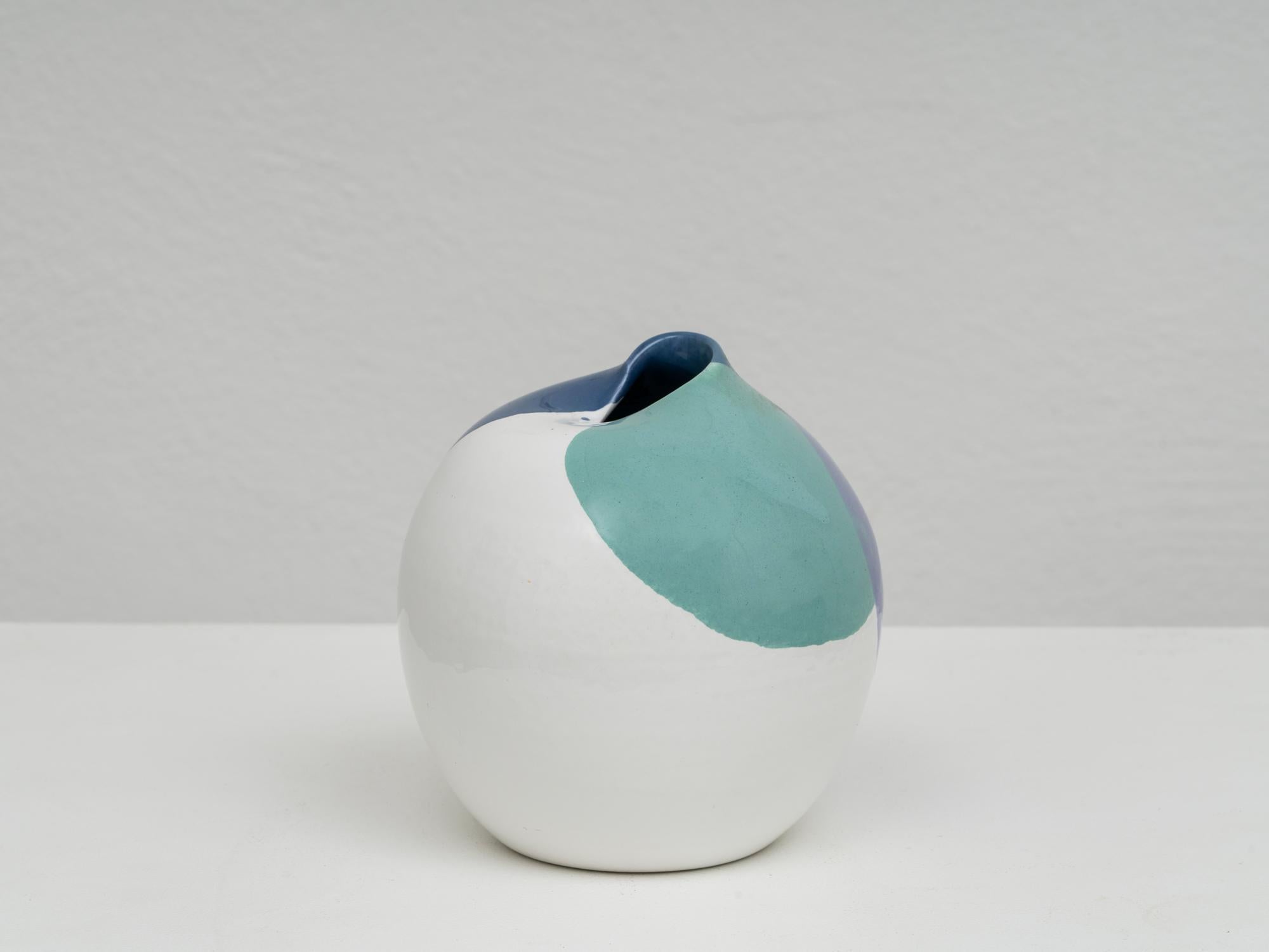 Postmodern ceramic vase by Pino Castagna, with a white glaze and a decor in a green-blue palette. This piece was manufactured in the artist's laboratoy in Costermano, near the Garda lake, in the 1990s. It is signed under the base and remains in good
