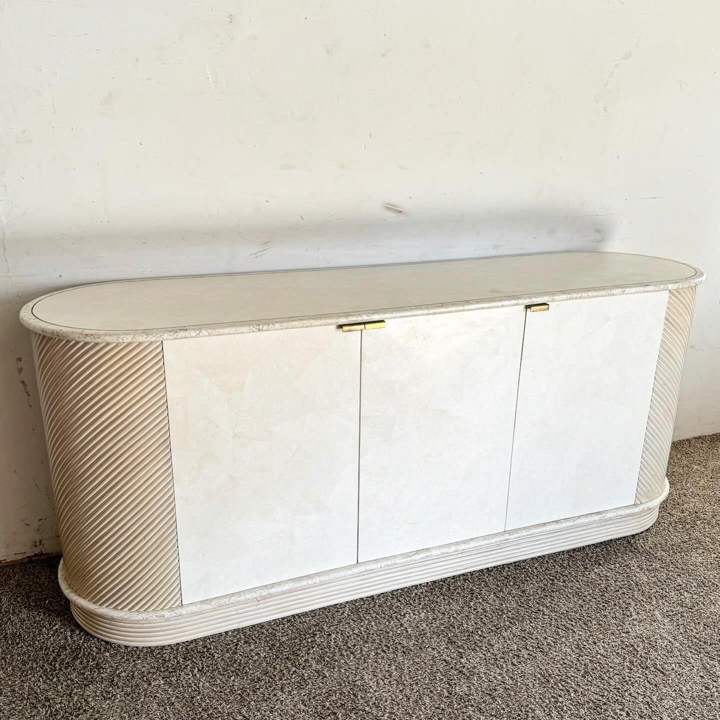 The Postmodern Chic Pencil Reed and Stone Credenza merges natural elegance with contemporary design. It features a unique blend of textured pencil reed and sophisticated stone, creating a striking furniture piece. Its modern silhouette and clean