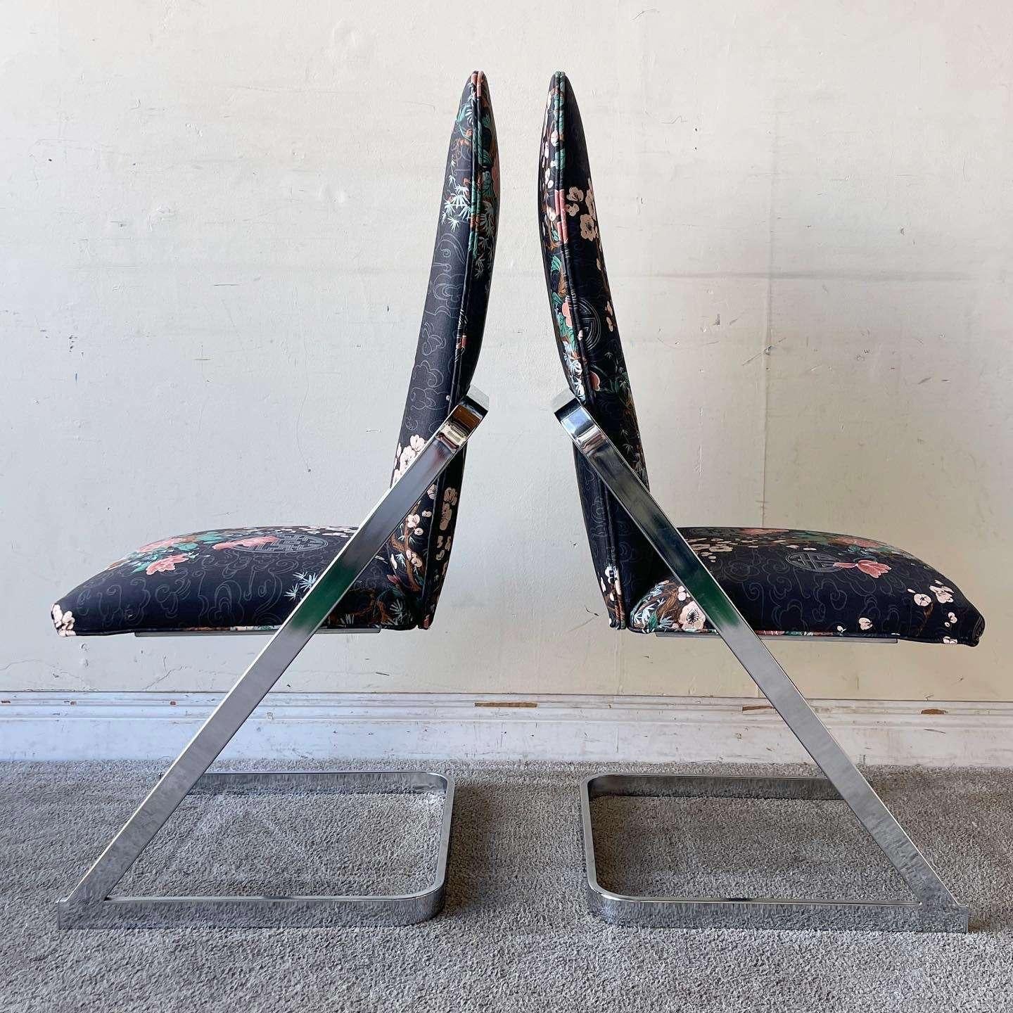 Superbe ensemble de 4 chaises de salle à manger postmodernes/chinoises à piétement luge. Chacune présente un tissu noir de style asiatique chinois décoré de représentations florales avec un cadre chromé.

La hauteur du siège est de 18,0 pouces.