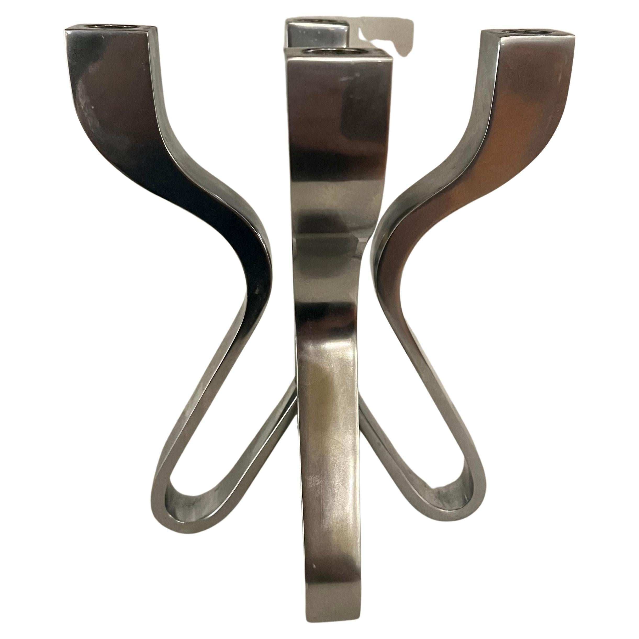 Striking candelabra. Described by their designer, Karim Rashid, as “sensual minimalism”, solid sleek awe-inspiring pieces of decorative art. Comprised of die-cast zinc with matte chrome plating. Rashid has been deemed one of the most prolific