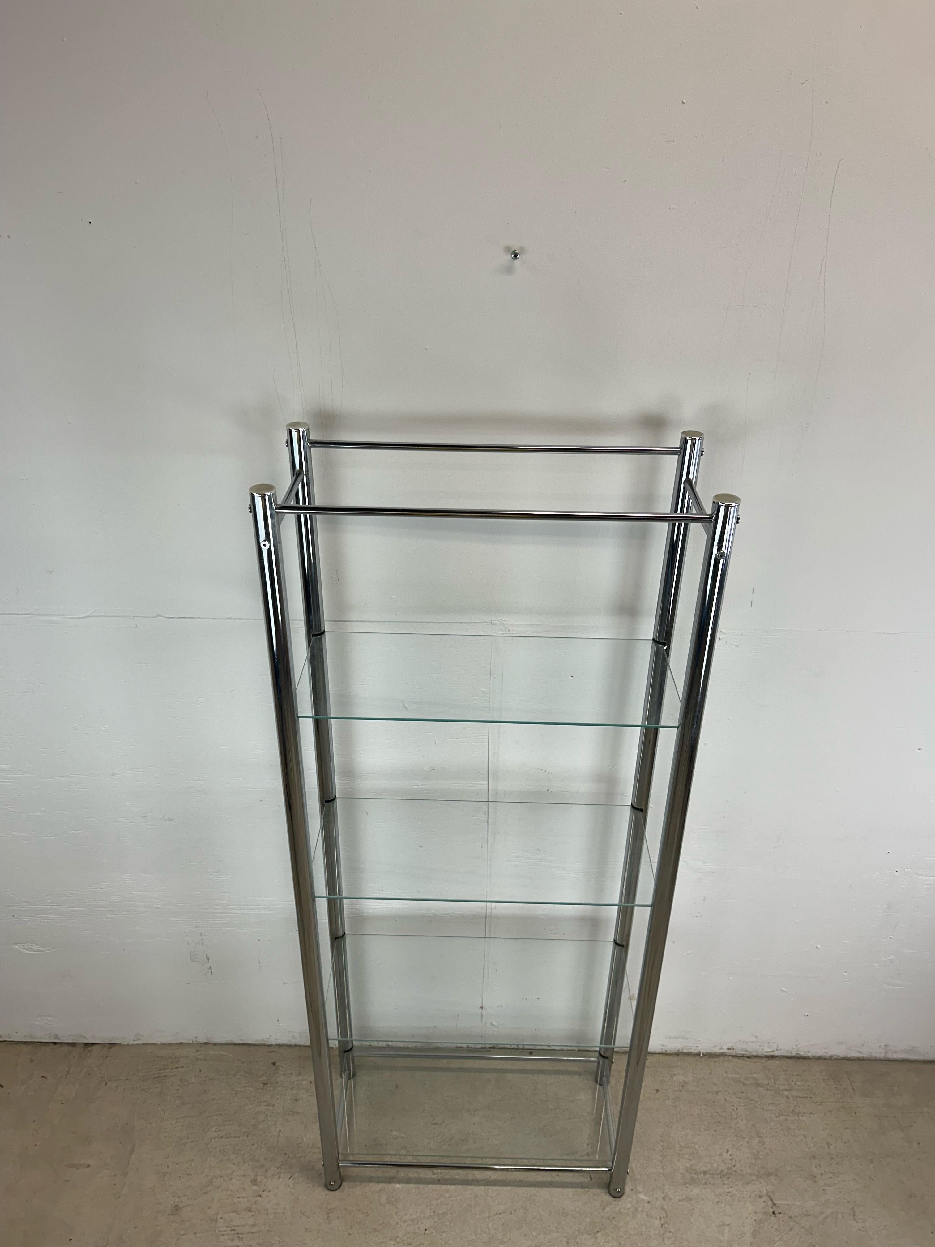 This postmodern etagere features polished chrome supports with four floating glass shelves.   14.5” between shelves.   Check out our other postmodern furniture listings!
 Dimensions: 25.5w 11.5d 63.25h 

Condition: Chrome uprights have some minor