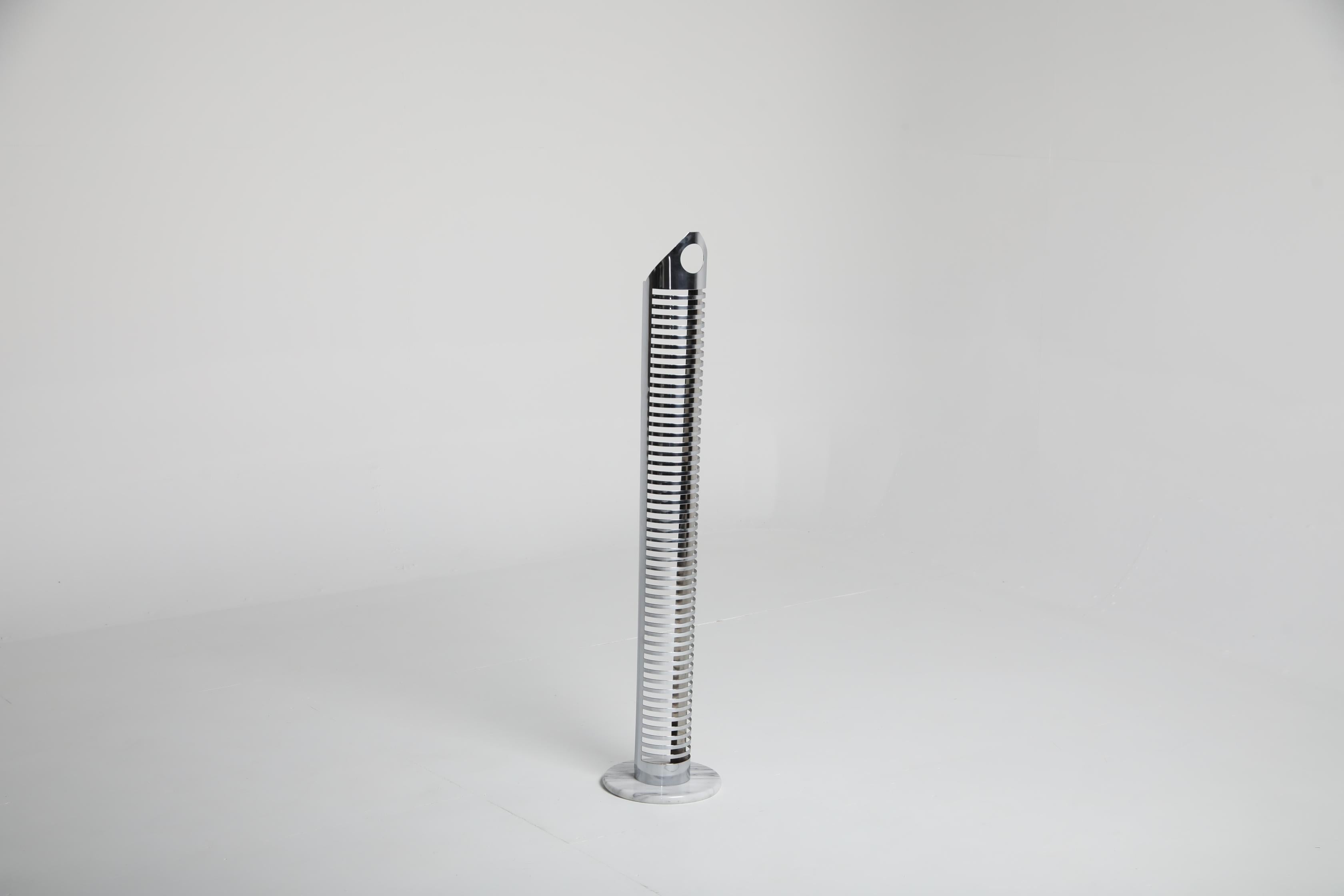 Tour CD produite dans les années 1980, construite en métal chromé avec une base circulaire en marbre gris. La forme verticale comporte des fentes régulièrement espacées conçues pour le rangement des supports, et la partie supérieure comprend une