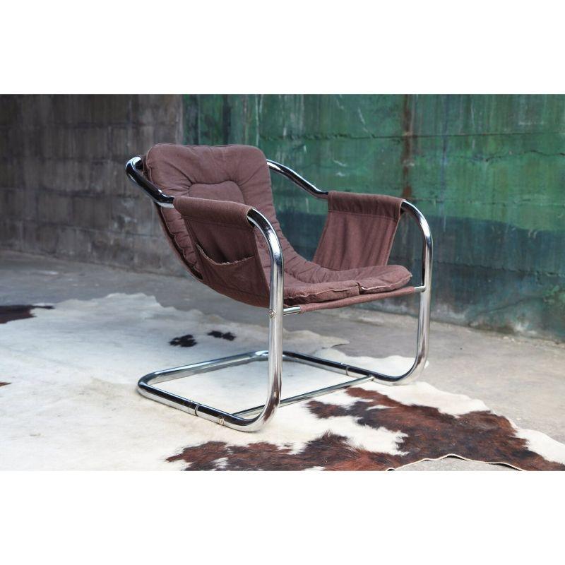 Great petit brown 70s reading chair. Very stylish and chic post modern chrome sling chair style. It makes a great reading chair for pretty much any type of space. The cushion is removable if you would ever wish to reupholster. It is classic as is,