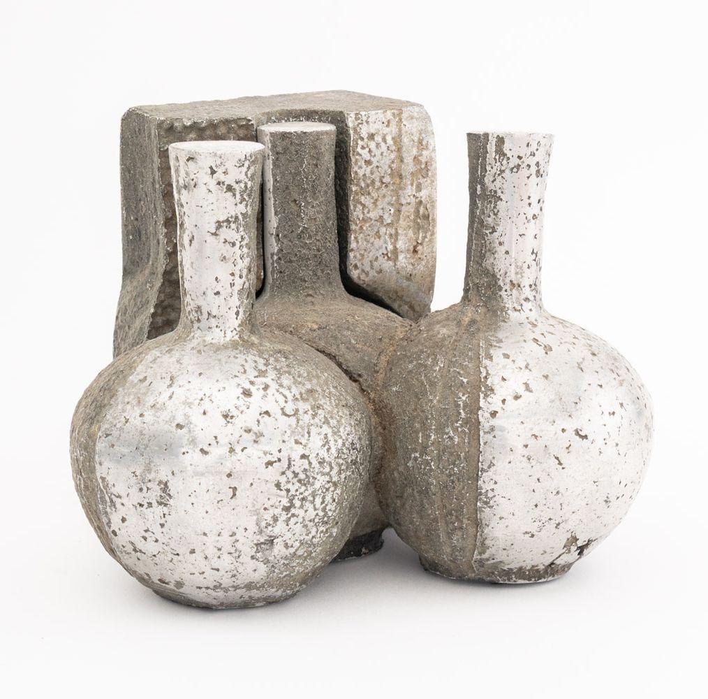 Scultura postmoderna in acciaio cromato in due pezzi, comprendente un vaso a forma di tre bottiglie e un pezzo separato di stampo angolare che si inserisce in un vaso; entrambi i pezzi sono marcati 