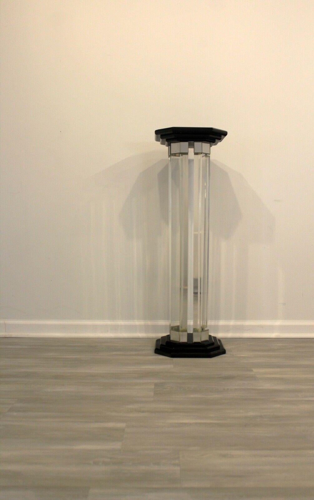 From Le Shoppe Too in Michigan, this postmodern pedestal brings together four lucite columns with a black base and top. Each column is detailed with a touch of mirrored veneer to disperse and refract light. In very good condition with few signs of