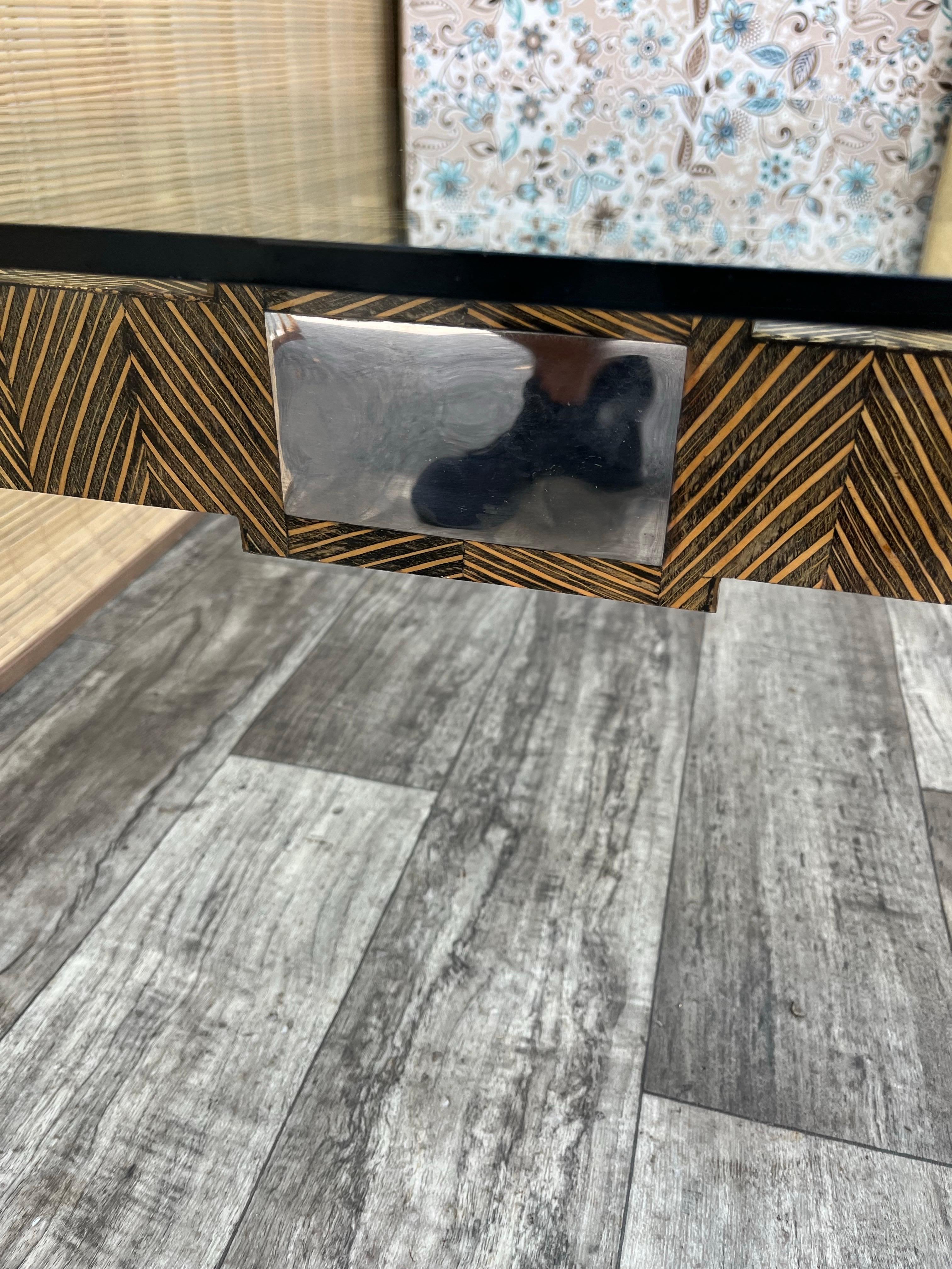 Table basse vintage postmoderne en bois de coco avec plateau en verre par Robb & Stucky. Circa 1990
Temper est composé d'un cadre solide en texture de bois de coco laqué avec des garnitures en métal et d'un plateau amovible en verre trempé avec des