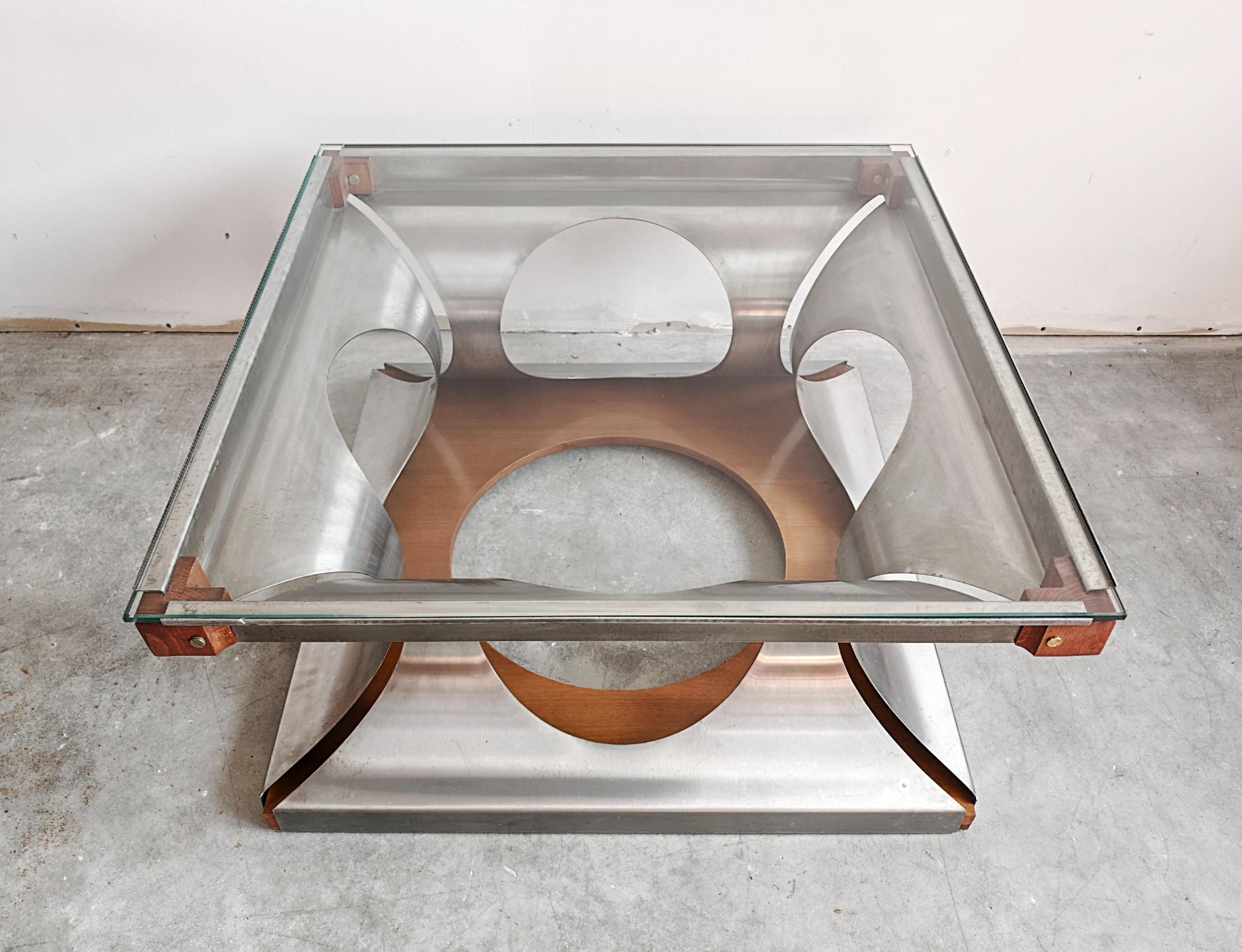 In this listing you will find a rare Space Age Coffee Table designed by Francois Monet for Kappa. It's sculptural base is made of steel, held together by the wood elements and glass top. Made in France in the 1970s.

Very good vintage condition with