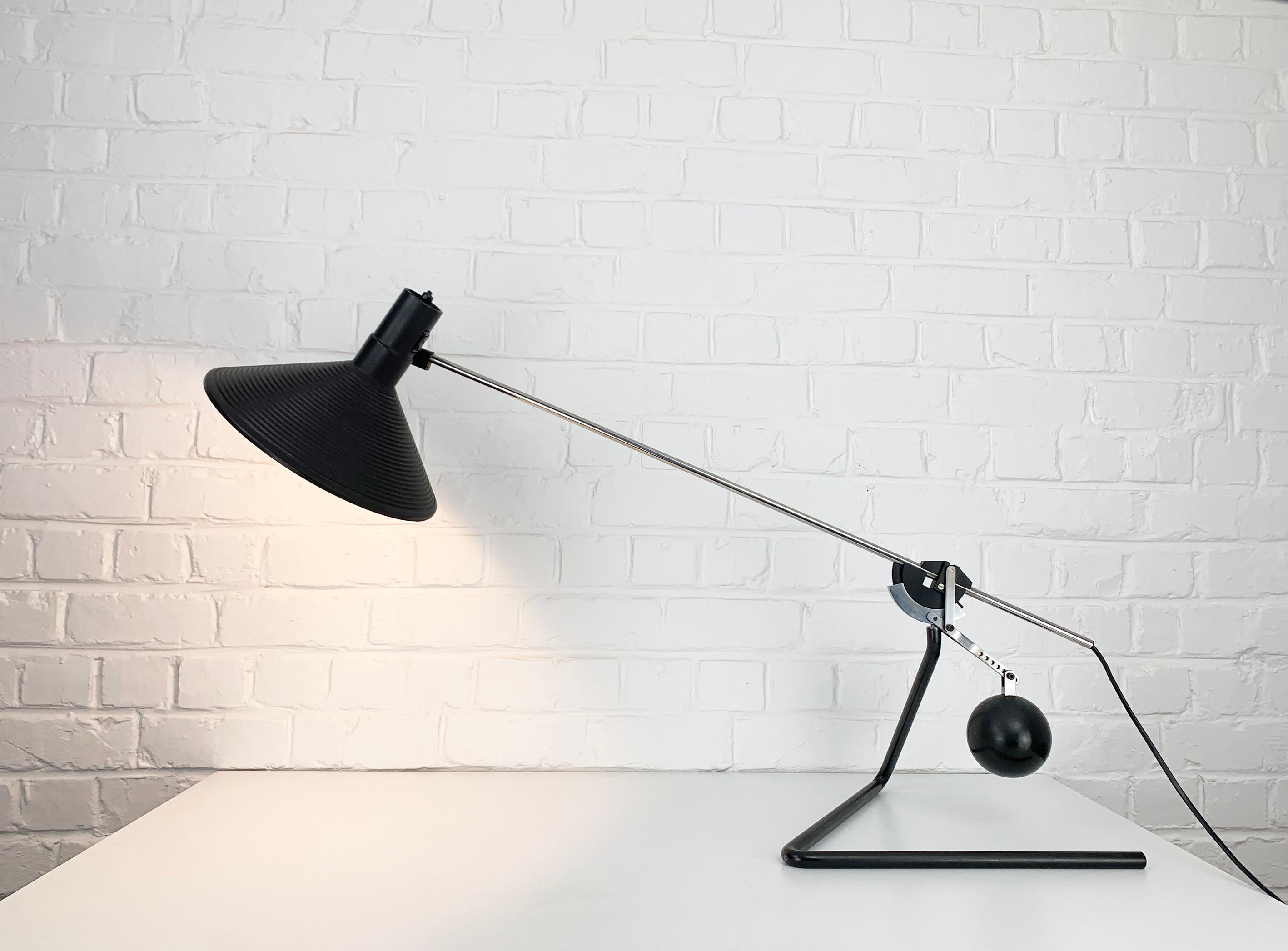 Ingenious desk lamp with a counterweight mechanism which allows the lamp to be stable in every position. The spheric counterweight is solid steel and heavy enough to point or position the lamp as desired. 

A throughout solid construction which