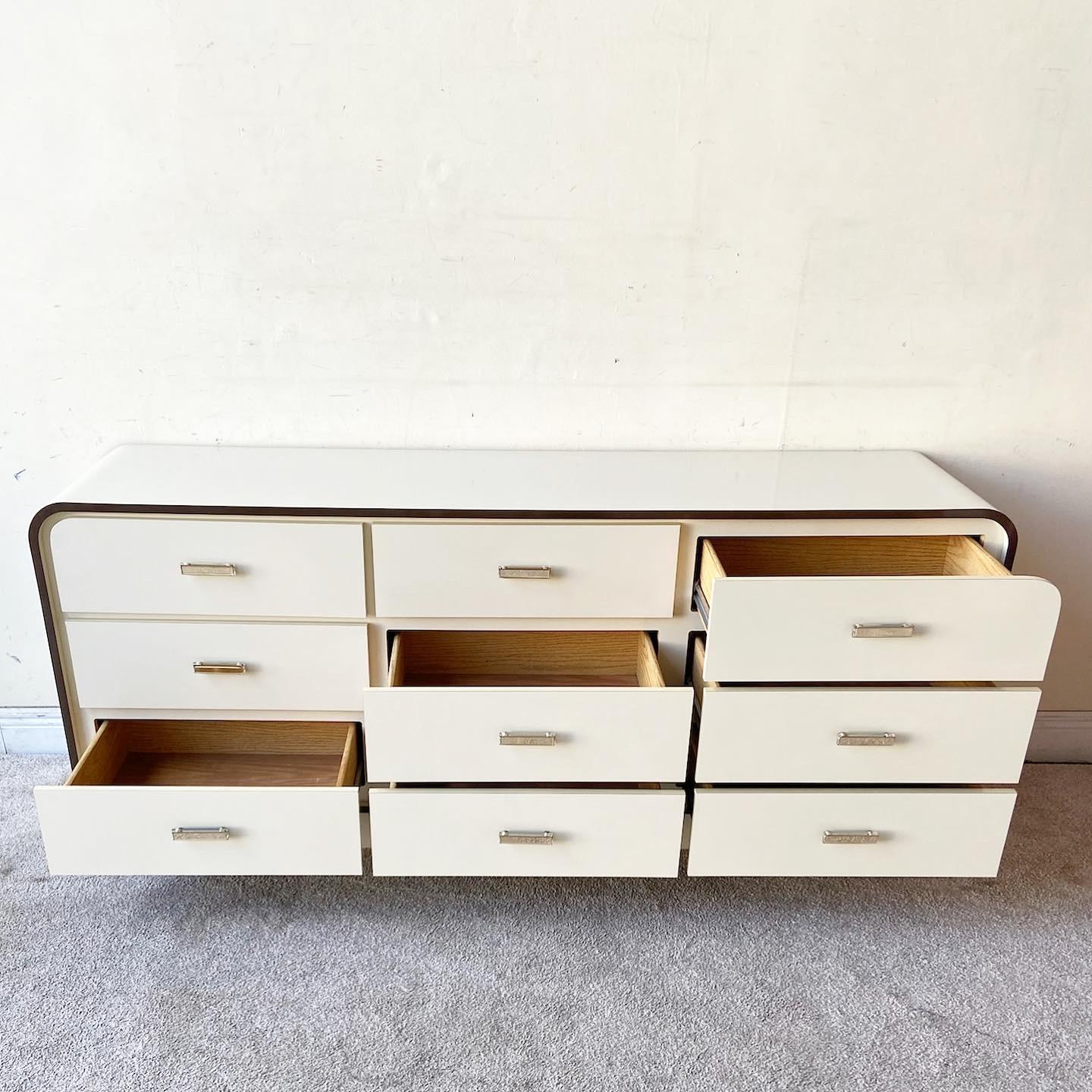 Excellent vintage Postmodern waterfall dresser. Features a cheese lacquer laminate with a brown laminate trim. Each of the 9 spacious drawers displays a lucite drawer pull.
Mirror measures 30.5” W, .5” D, 44” H.
