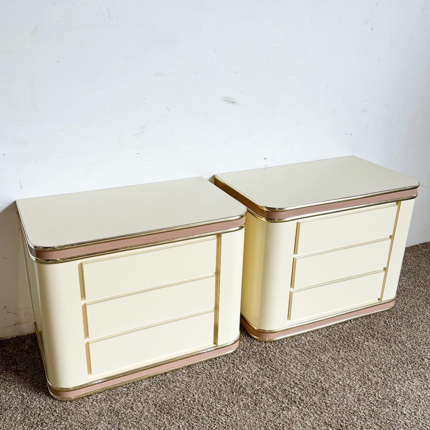 Elevate your bedroom with the contemporary elegance of the Postmodern Cream and Pink Lacquer Laminate Nightstands with Gold Trim. These nightstands feature a striking cream and pink high-gloss lacquer finish, enhanced by durable laminate surfaces.