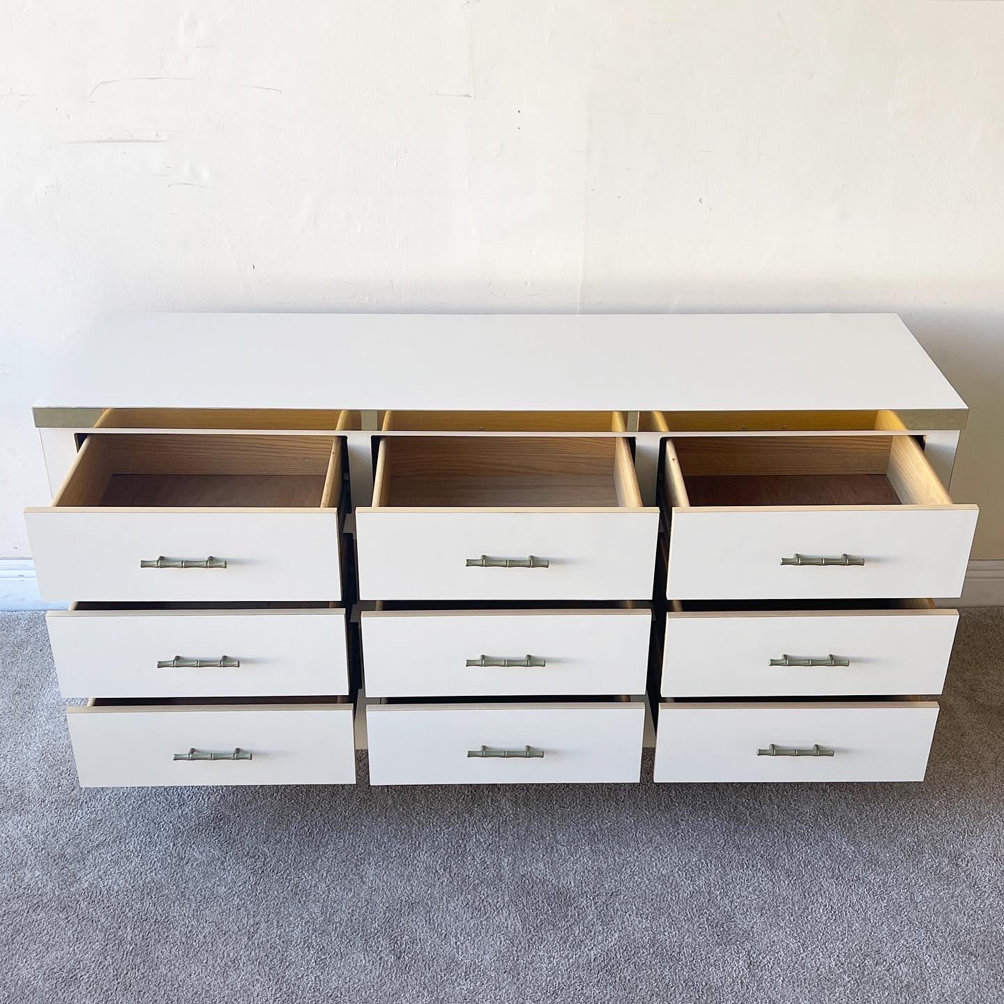 Amazing postmodern triple dresser features a cream lacquer laminate. Each drawer has a faux bamboo brass handle and top top of the dresser has a gold strip bordering the top.

Additional information:
Material: Brass, wood
Color: Cream,