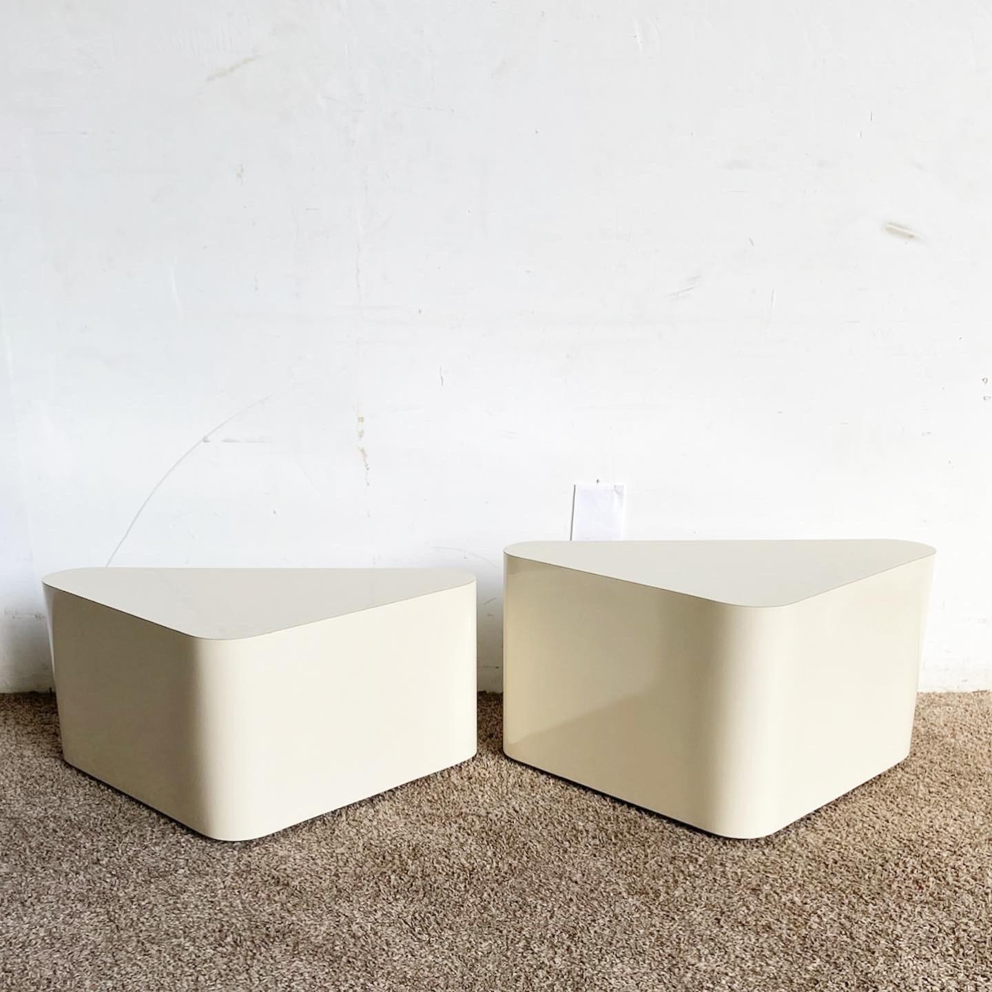 Add a modern touch to your living space with these Postmodern Cream Lacquer Laminate Triangular Nesting Side Tables. Perfect blend of style and functionality.

Dimensions: Shorter table has a height of 13.75‚Äù
Material: Finished in sleek cream
