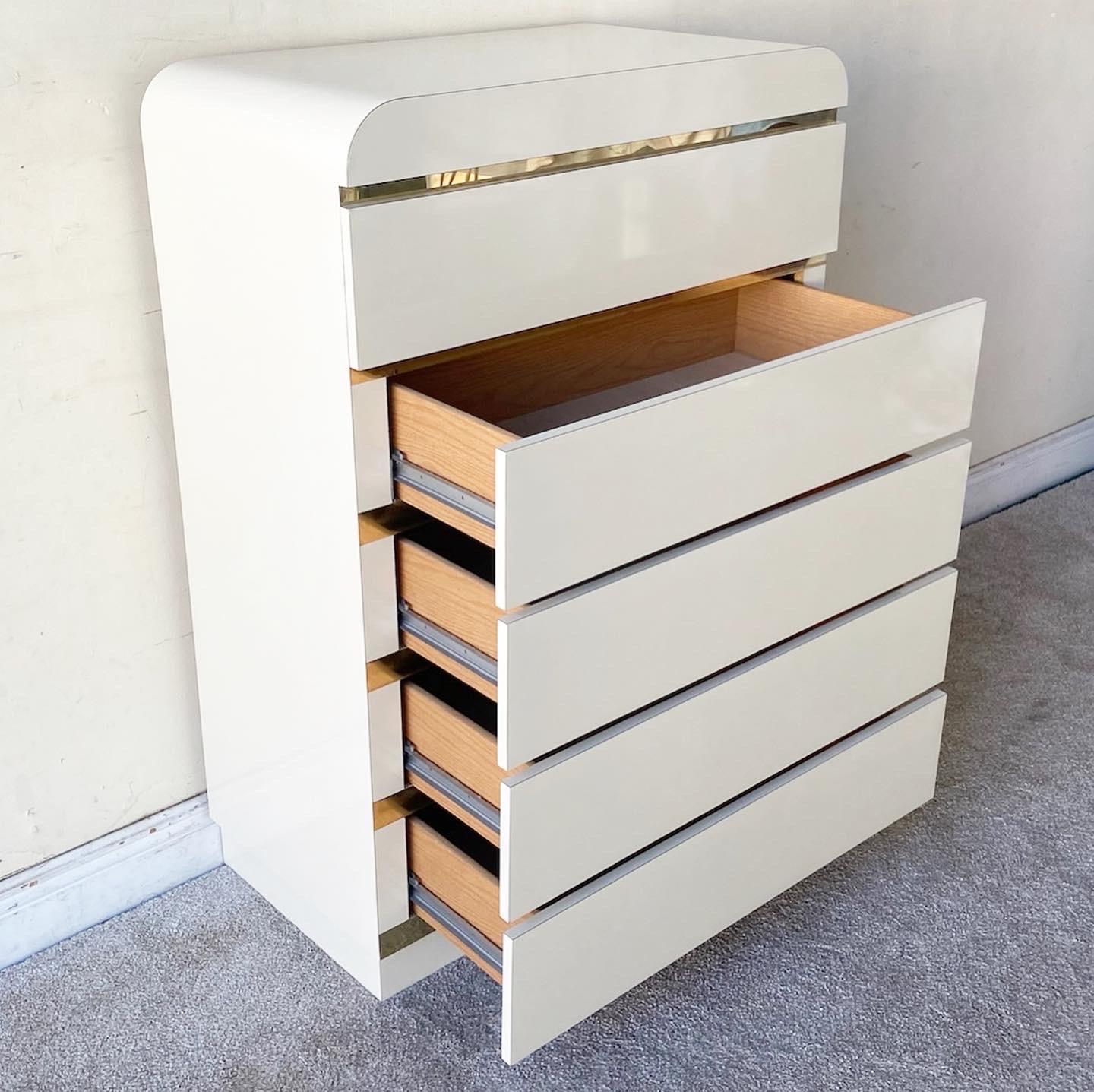 Amazing vintage postmodern waterfall Highboy dresser. Features a cream lacquer laminate with gold trim and 5 spacious drawers.
 