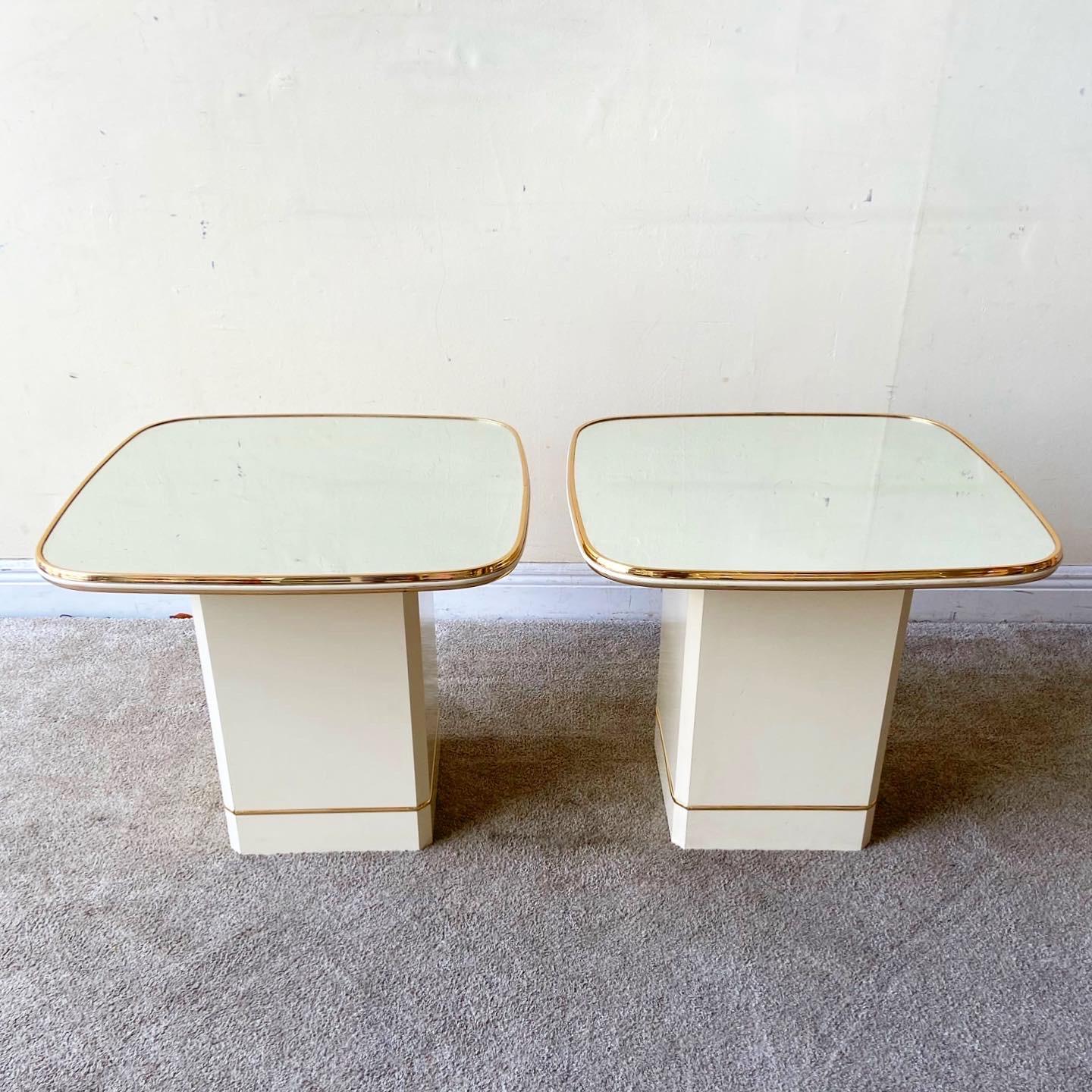 Incredible pair of postmodern 1980s rounded square top side tables. Each chair features a mirrored top with a gold trim.
 