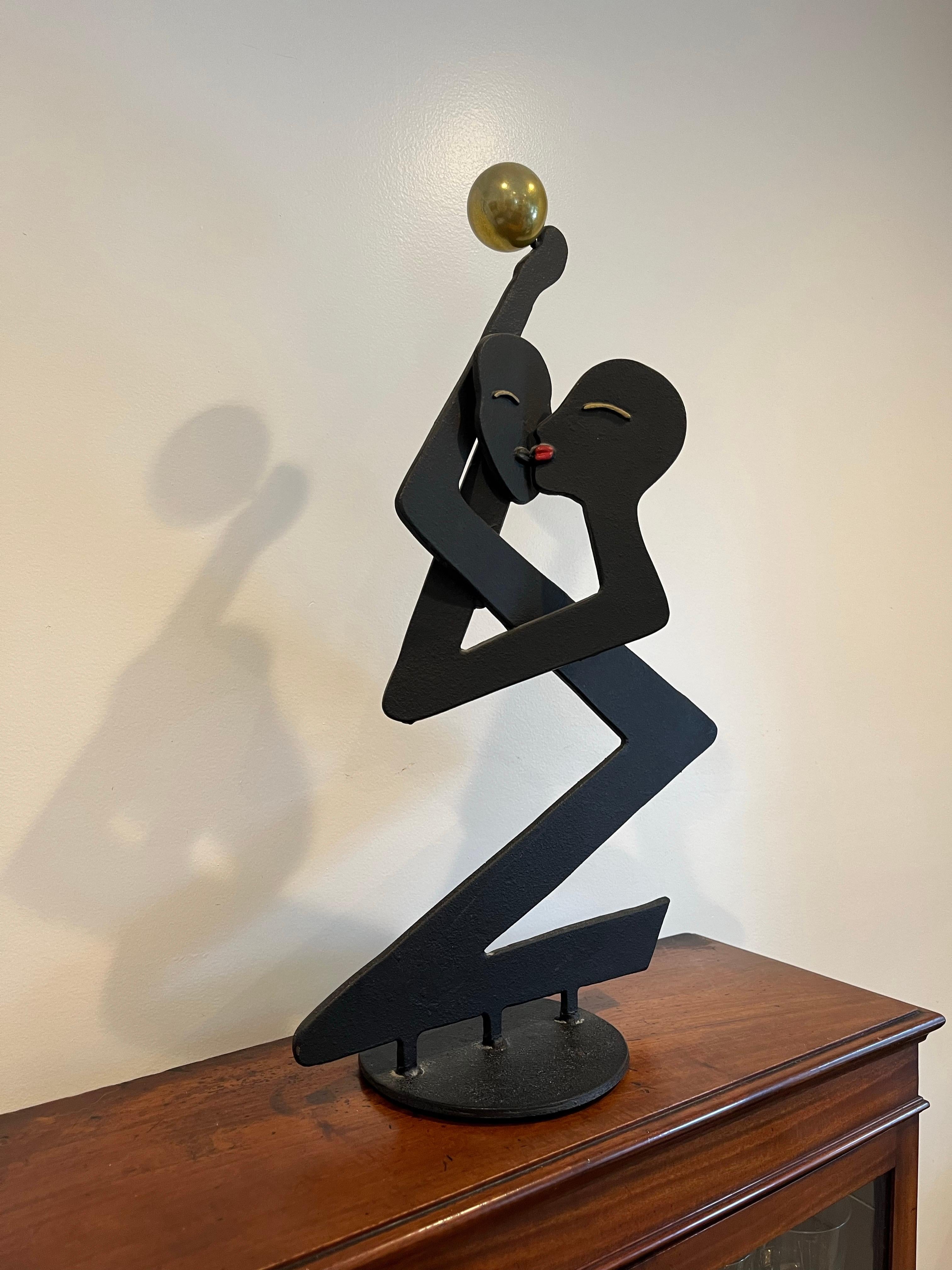 Sculpture unique de Curtis Jere représentant un couple qui s'embrasse. Sculpture en acier noir aux lignes épurées et fantaisistes projetant de grandes ombres tout au long de la journée. Finition noire mate surmontée d'un épi de faîtage en forme de