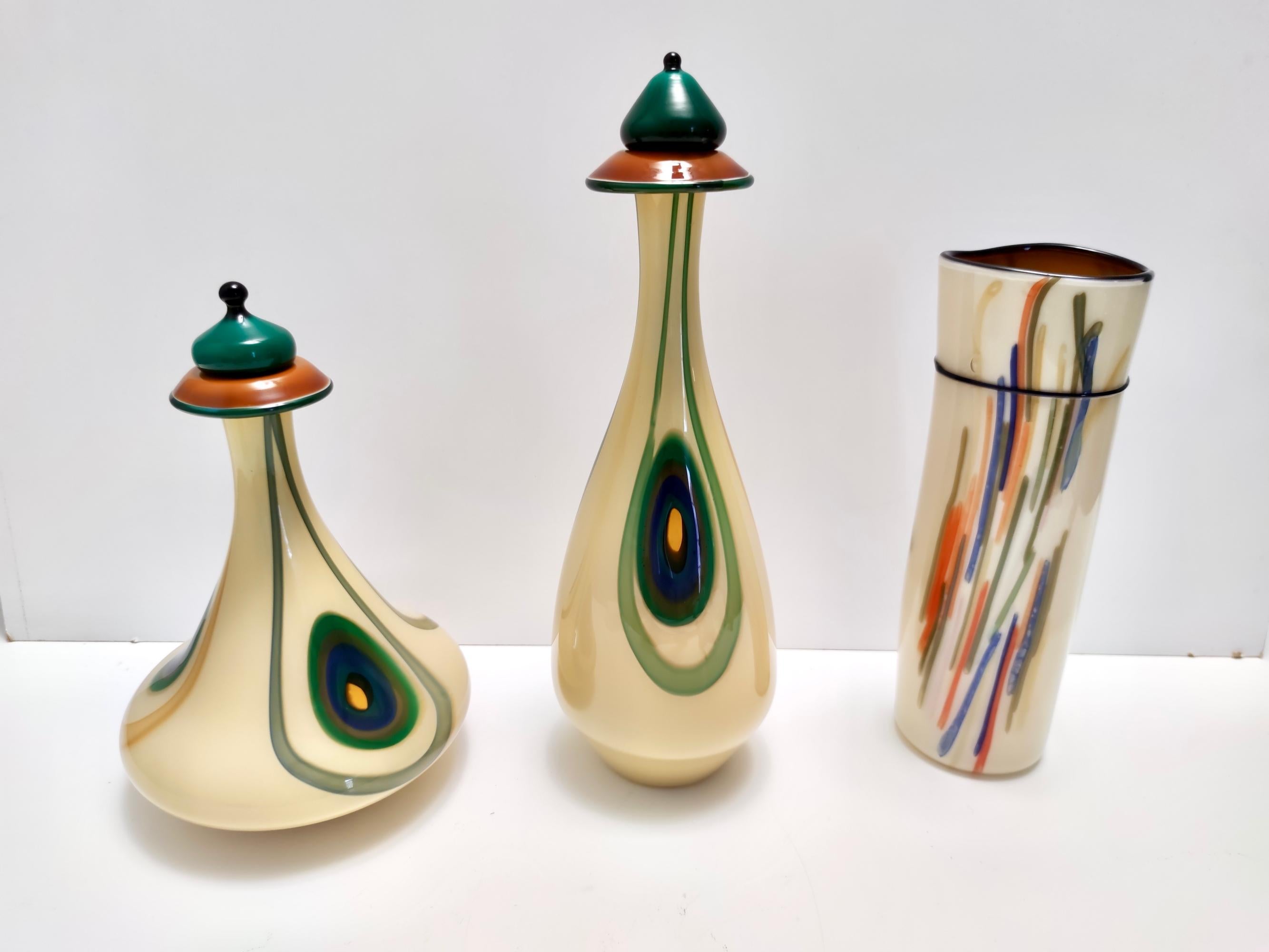 Made in Italy, 1960s - 1970s.
This vase is part of a three-piece set. 
It is made in encased opaline and hand-blown glass with colored canes.  
This is a vintage item, therefore it might show slight traces of use, but it can be considered as in