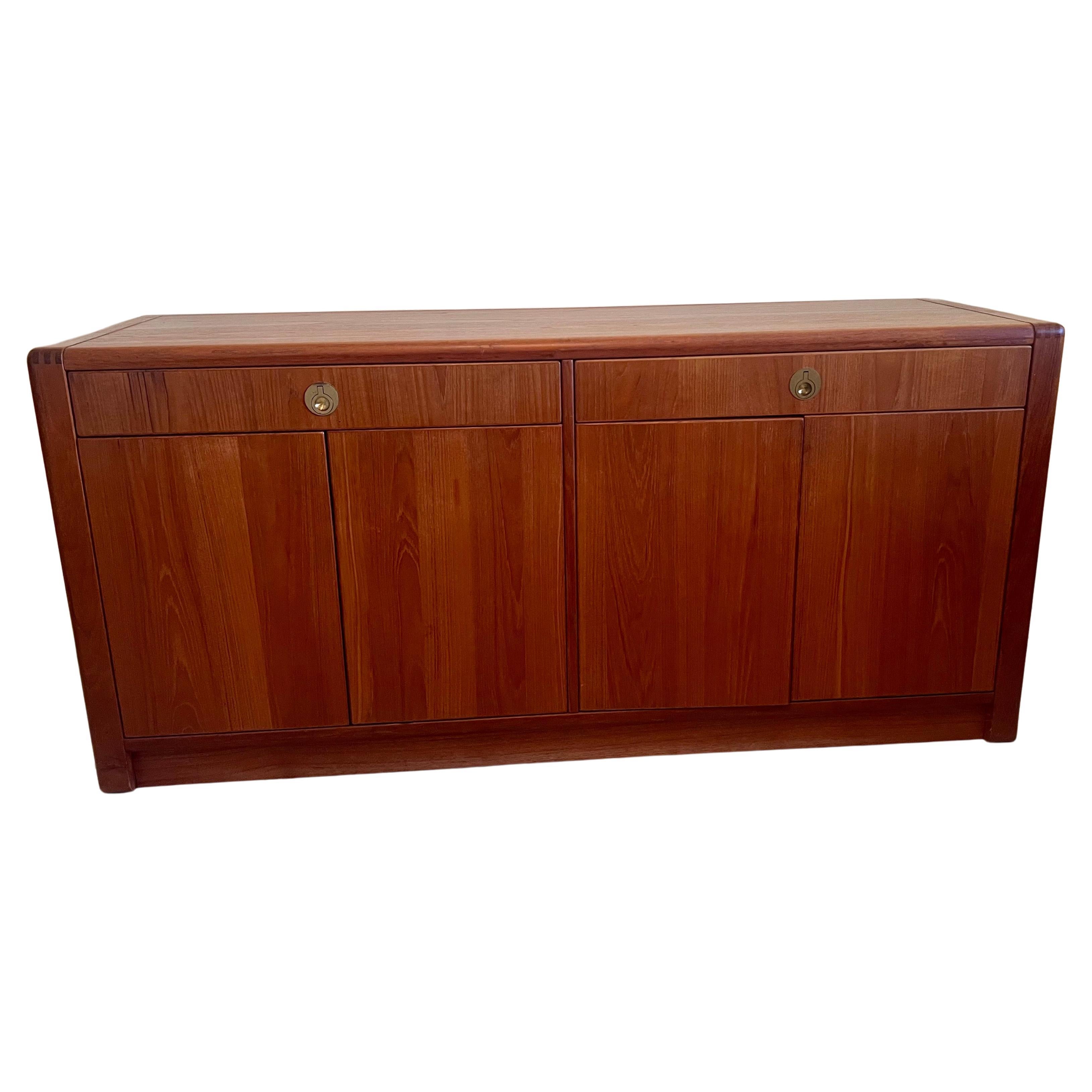 A beautiful Danish modern Teak credenza , circa 1980's beautiful detail rounded corners construction , double drawer with beautiful solid brass flat handles nice condition lots of storage beautiful dark teak.