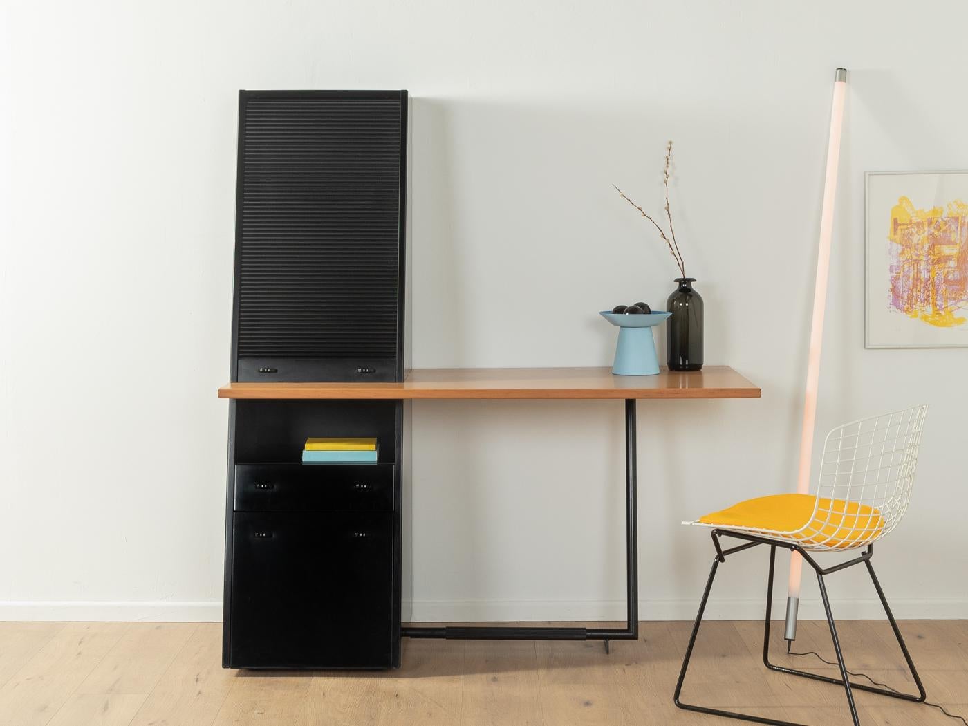 Postmodern desk by interlübke from the 1980s. Corpus in black with two drawers, a roller shutter door and various storage compartments, a table top and a frame made of black lacquered steel.
Quality Features:

    good workmanship
    high-quality