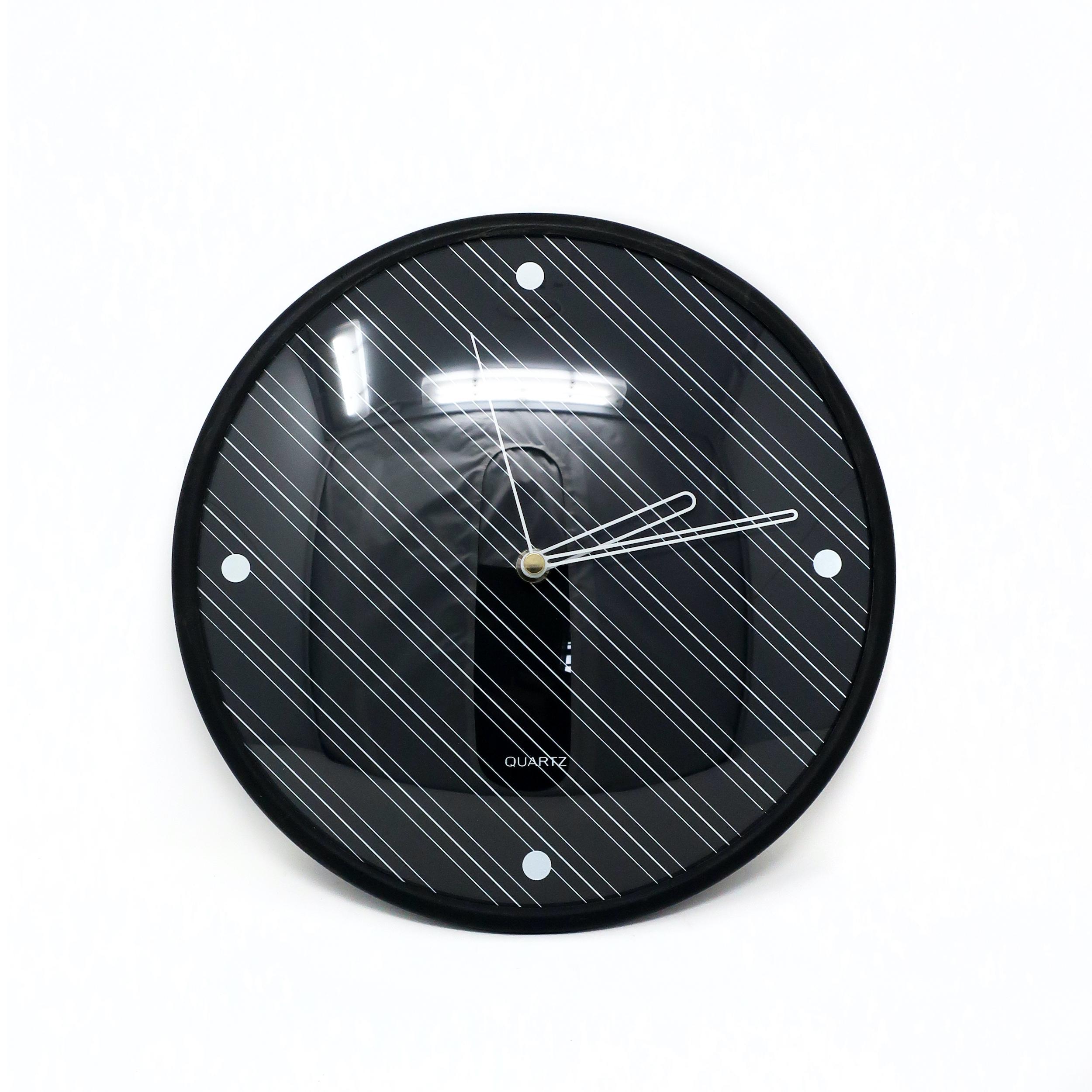 A striking 1980s black wall clock with diagonal pin stripes at a 45 degree angle and white pin stripe hands. Produced by Baker Hart & Stuart, a home goods brand for the department store chain Mervyns that was well known for its ceramic goods, but
