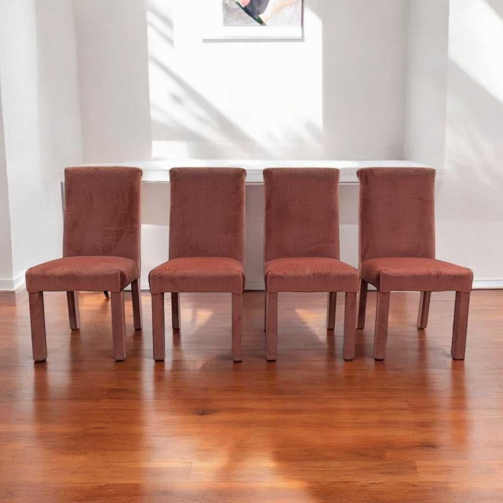 Un caratteristico set di sedie da pranzo nella tradizione postmoderna degli anni '80, completamente rivestito in velluto rosa salmone con una sottile trama geometrica. Queste sedie scultoree con schienale alto sono caratterizzate da gambe massicce e