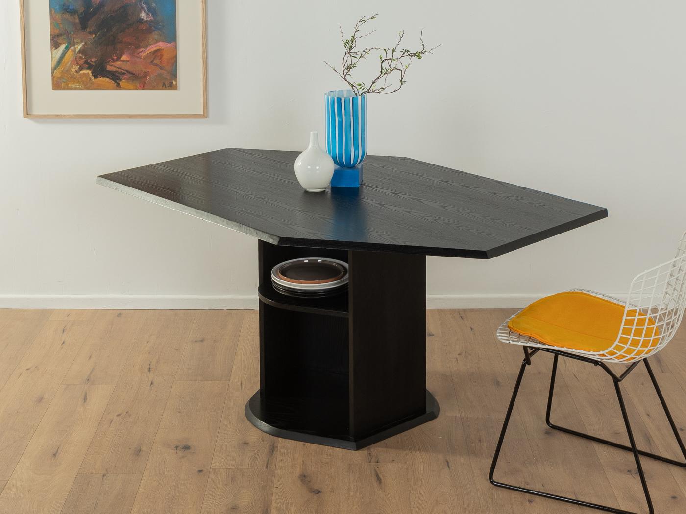 Postmodern dining table from the 1980s in the style of Stefan Wewerka with a table top in black stained solid ash wood and a base in black stained ash veneer. The base was designed as a shelf.
Quality Features:

    very good workmanship
   