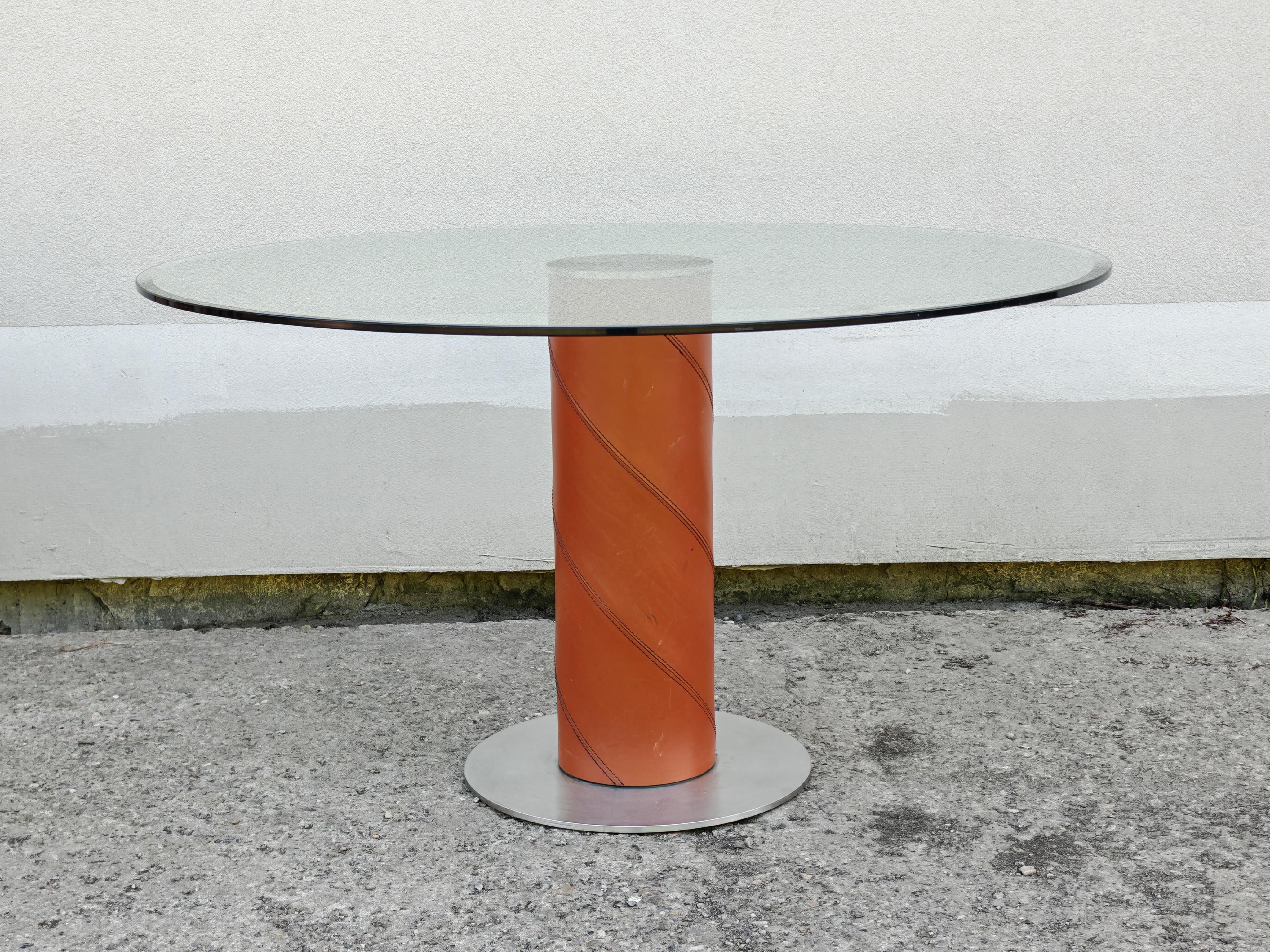 Vous trouverez dans cette liste une rare table de salle à manger postmoderne conçue par Giancarlo Vegni pour Fasem. La table est composée d'une base en acier et en cuir de selle et d'un plateau rond en verre épais. Fabriqué en Italie dans les années