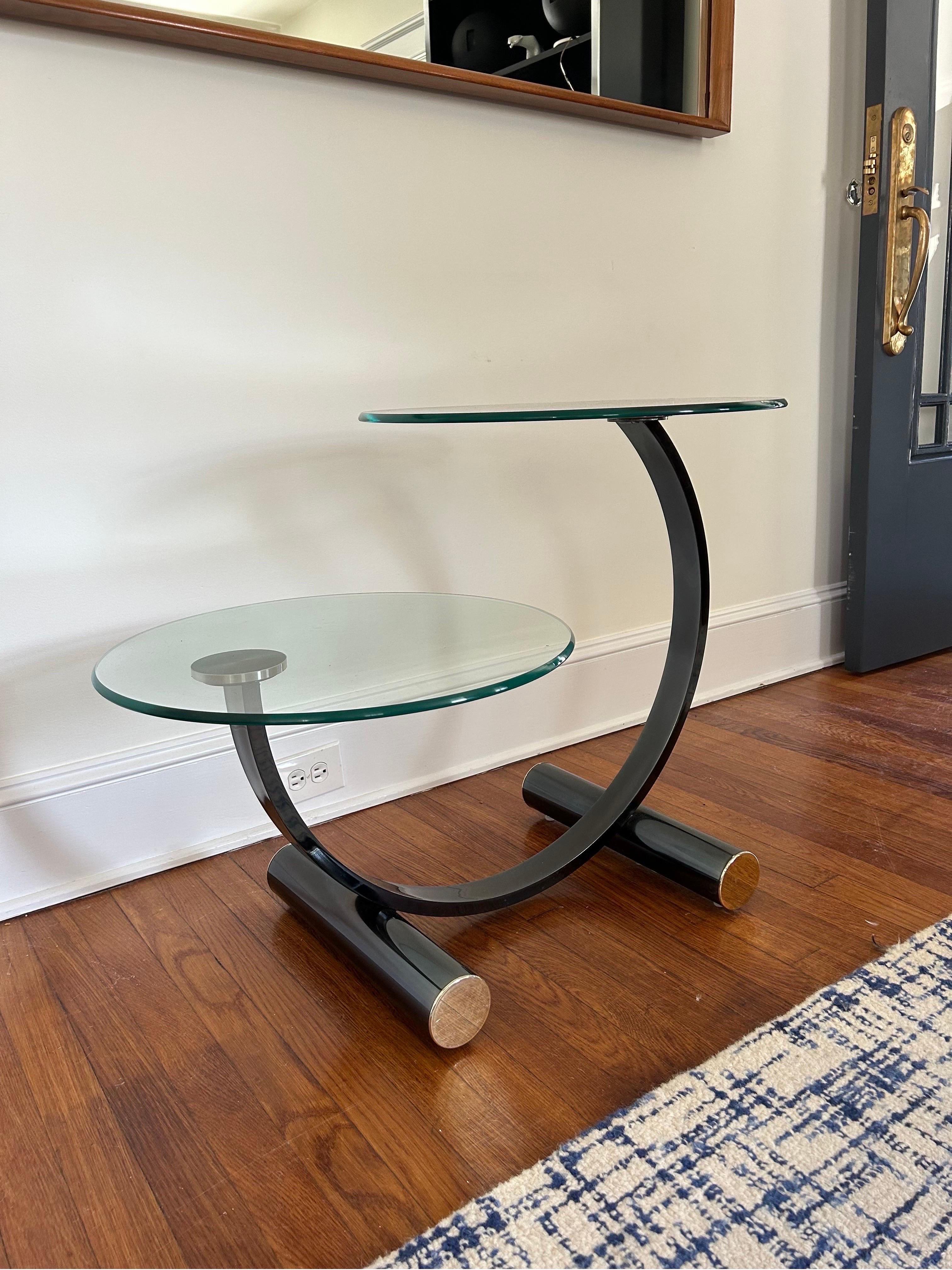Great 2 Tiered side table in the manner of Donald Deskey. Steel tubular base with polished brass caps. 2 large circular glass surfaces suspended on arched frame.
Curbside to NYC/Philly $350 