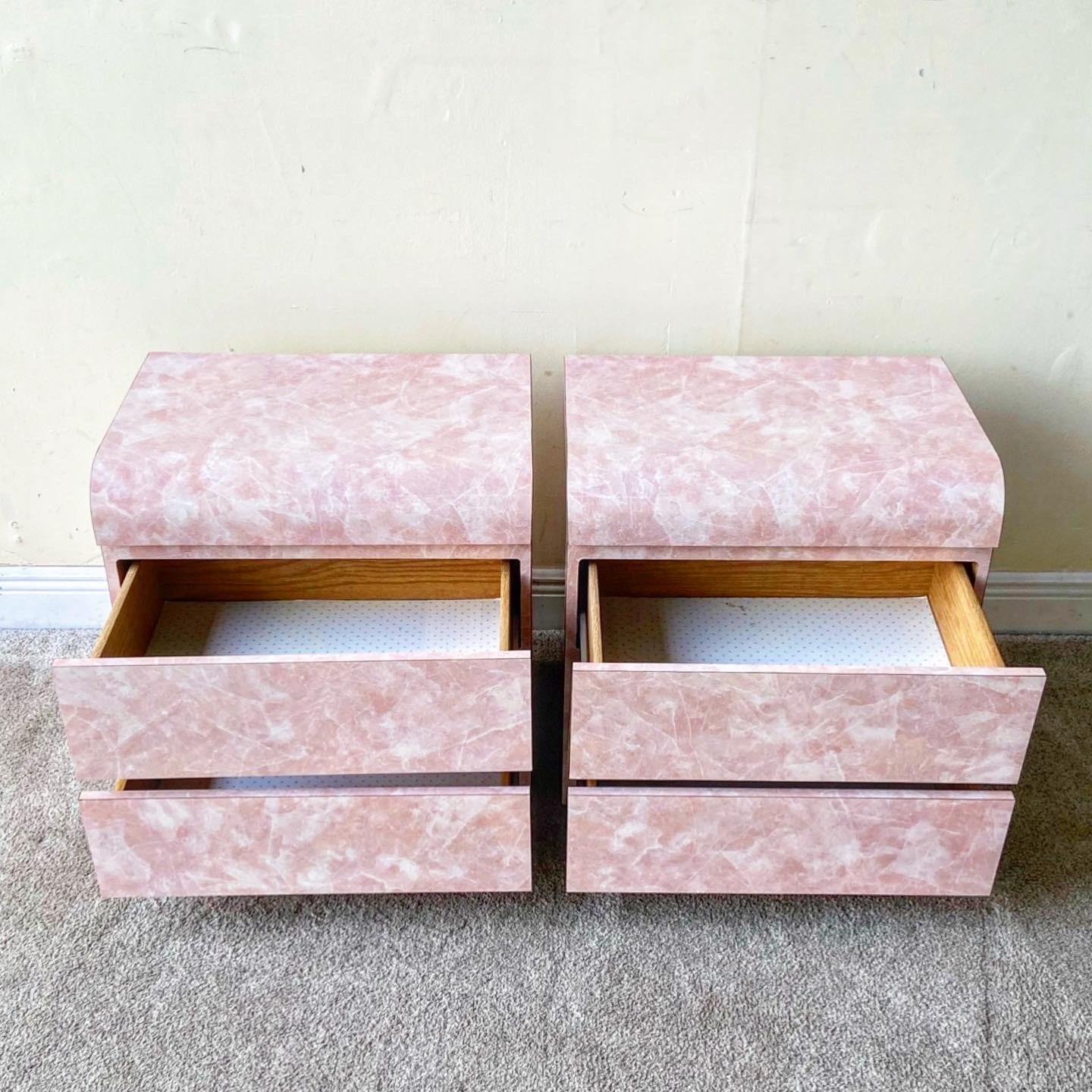 Incredible pair of postmodern waterfall Nighstands with two spacious drawers each. Features a pink and white faux marble gloss laminate.
 