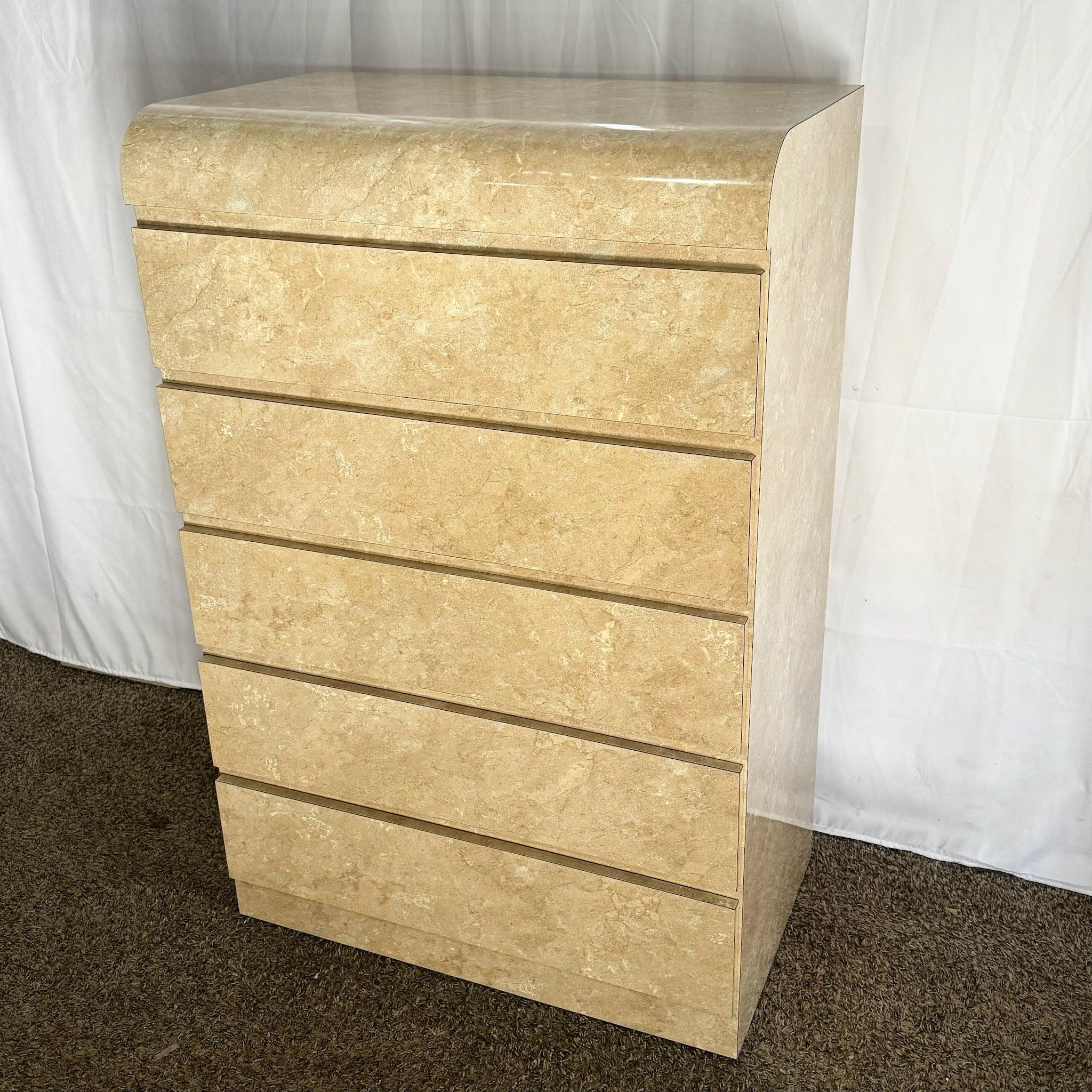 Commode haute postmoderne en stratifié marbré faux Tan/Beige avec cinq tiroirs spacieux et un design épuré en forme de cascade, parfait pour les intérieurs contemporains.
 
 Nous vendons les articles tels qu'ils ont été acquis, sans les restaurer ni
