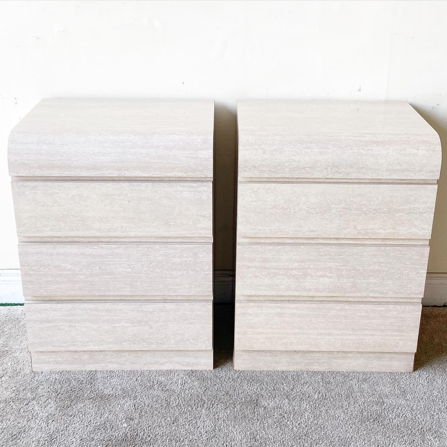 Amazing pair of postmodern waterfall nightstands. Each features 3 spacious drawers and a faux travertine laminate.