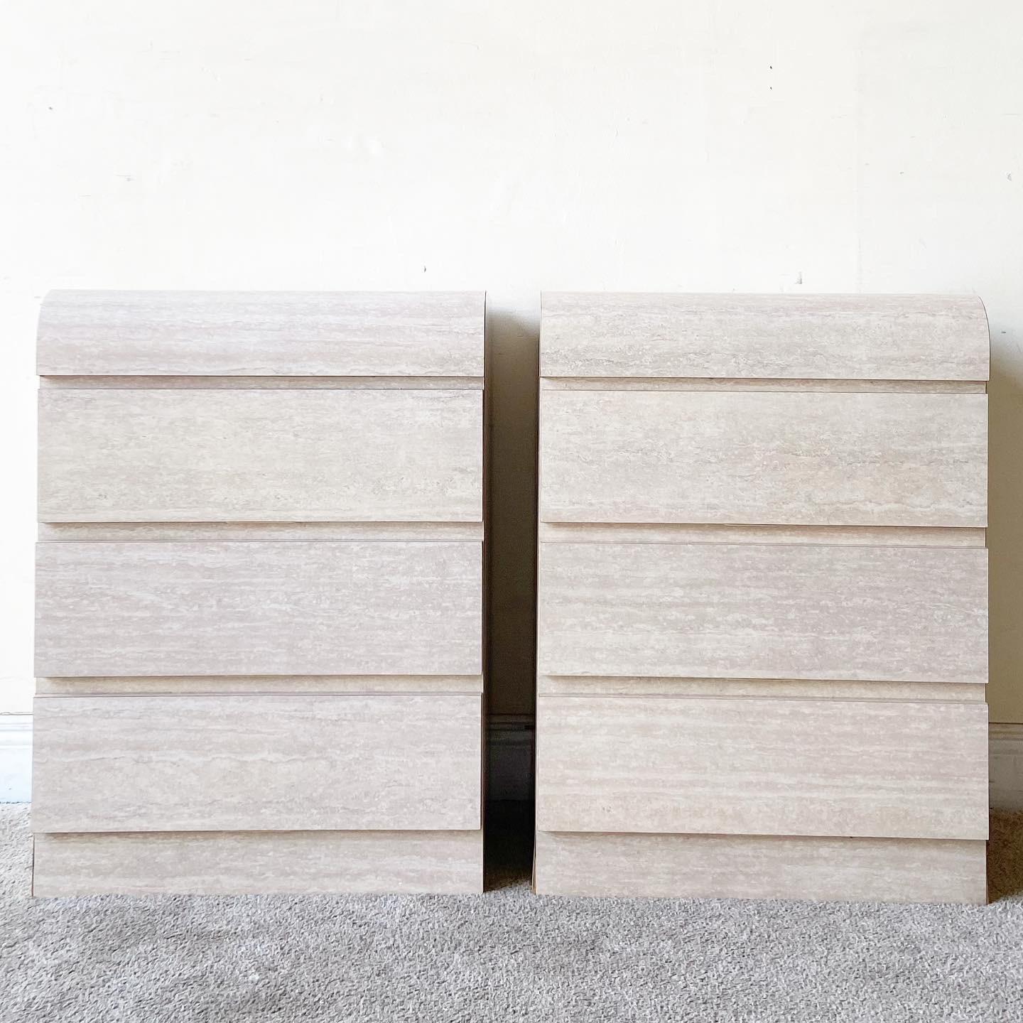 Amazing pair of postmodern waterfall nightstands. Each features 3 spacious drawers and a faux travertine laminate.
   