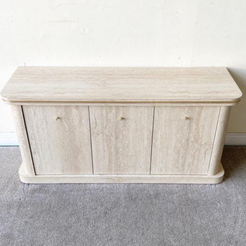 Incredible faux travertine laminate credenza with gold trim. Features three cabinet door which open to a spacious shelving area. It’s on wheels!

Additional information:
Materials: Wood
Color: Beige, Brown, Gold, Tan
Style: Postmodern
Time Period: