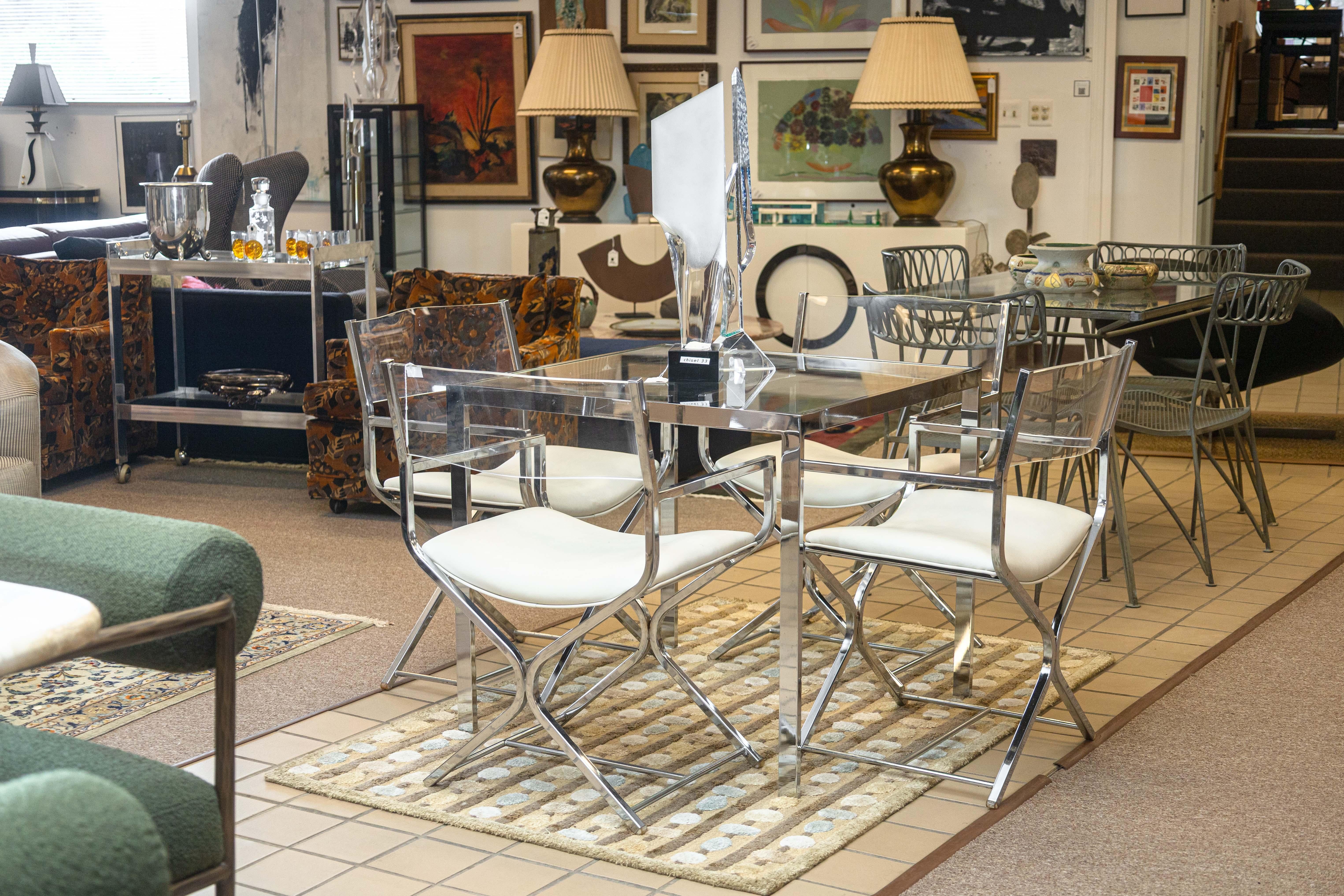 A postmodern chrome and glass dinette game table. This chic game table has a simple, modern design, perfect for a kitchen or dining room nook. The table features a flat bar chrome frame, and a square glass tabletop. This table is in good overall