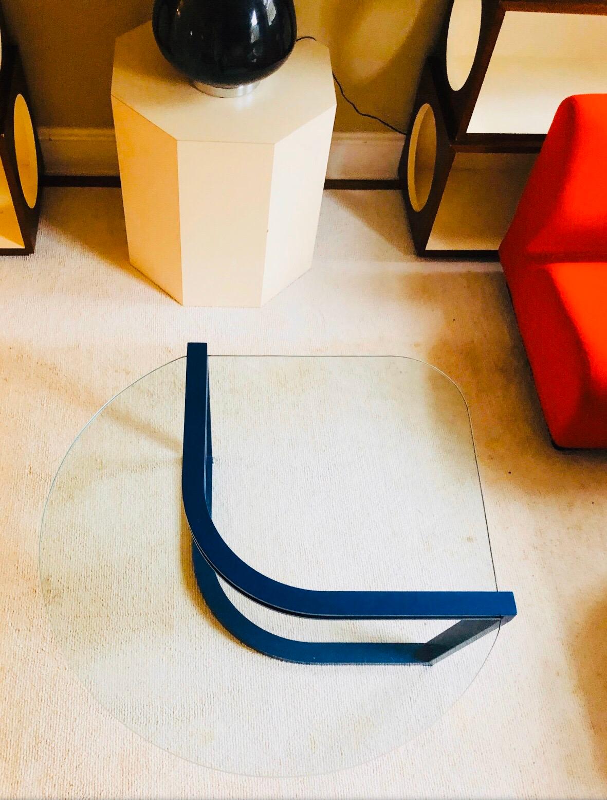 Fantastic Postmodern table by DIA. 

This piece is really a feat of dynamics, the glass slides into the blue flat bar base and stays suspended due to the placement of where the glass meets the metal. 

Makes a room pop!

Not recommended for homes