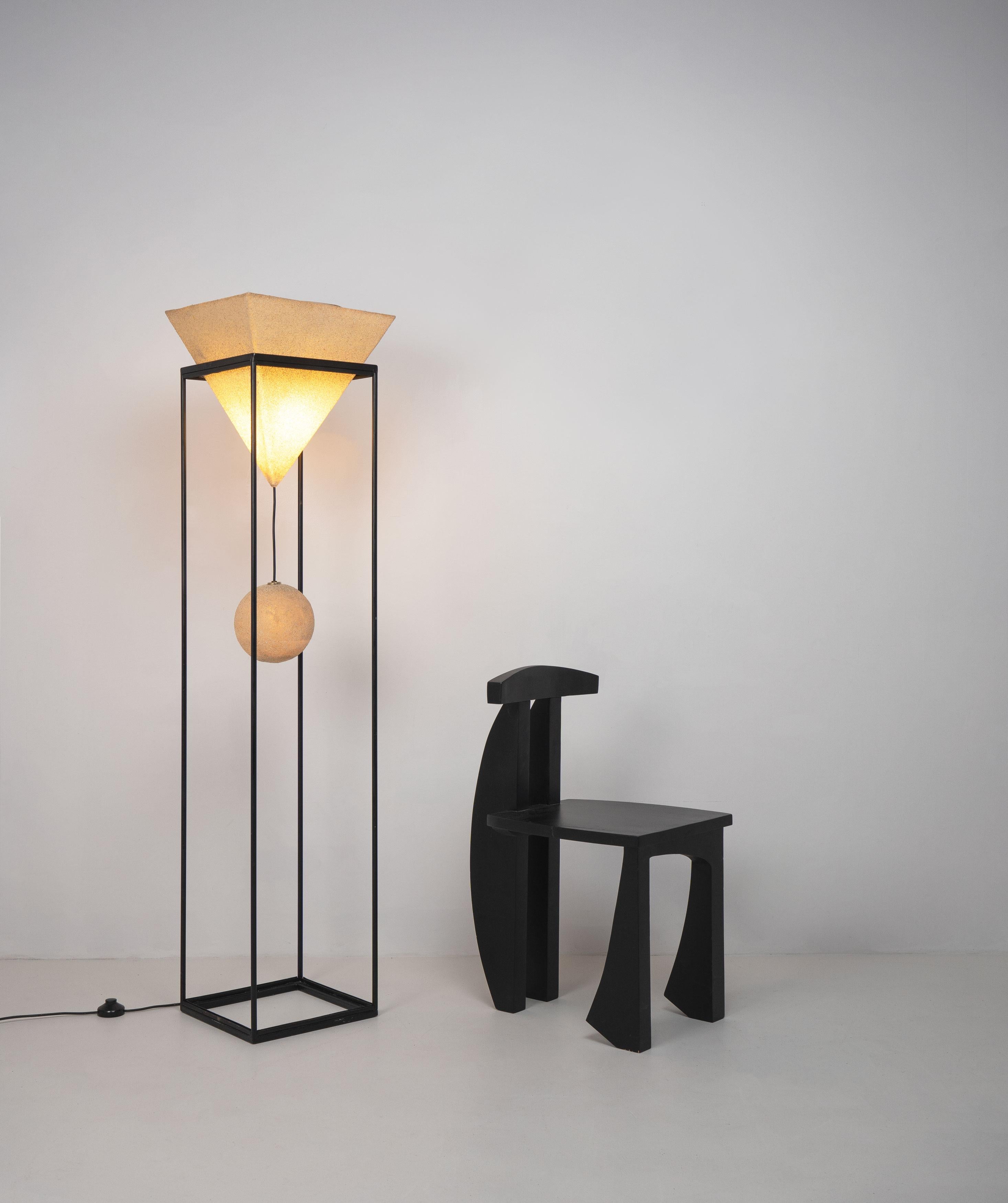 A Postmodern floor lamp designed by Luciano Sartini and manufactured by Singleton, Italy, c.1970. Featuring an inverted pyramidal resin shade from which suspends an additional spherical resin light, supported by a metal cuboid frame. 

Dimensions