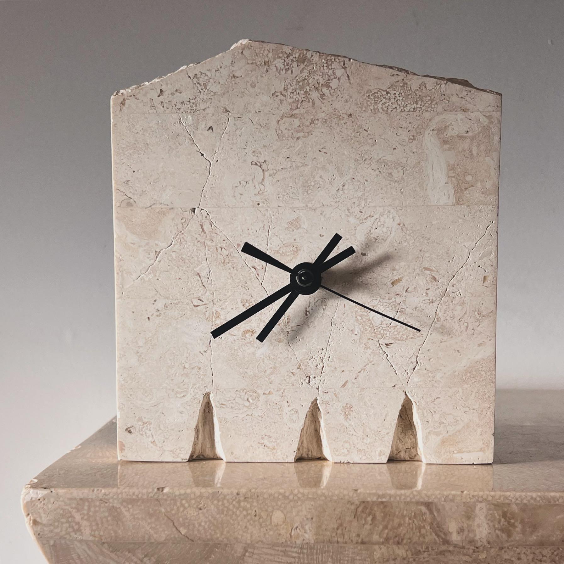 A vintage postmodern table clock in faux travertine - fossil stone or soapstone - with “Roman ruins” detail, late 20th century. Made in the Philippines, this item exudes neoclassical sensibilities as well as postmodern minimalism. Black velveteen