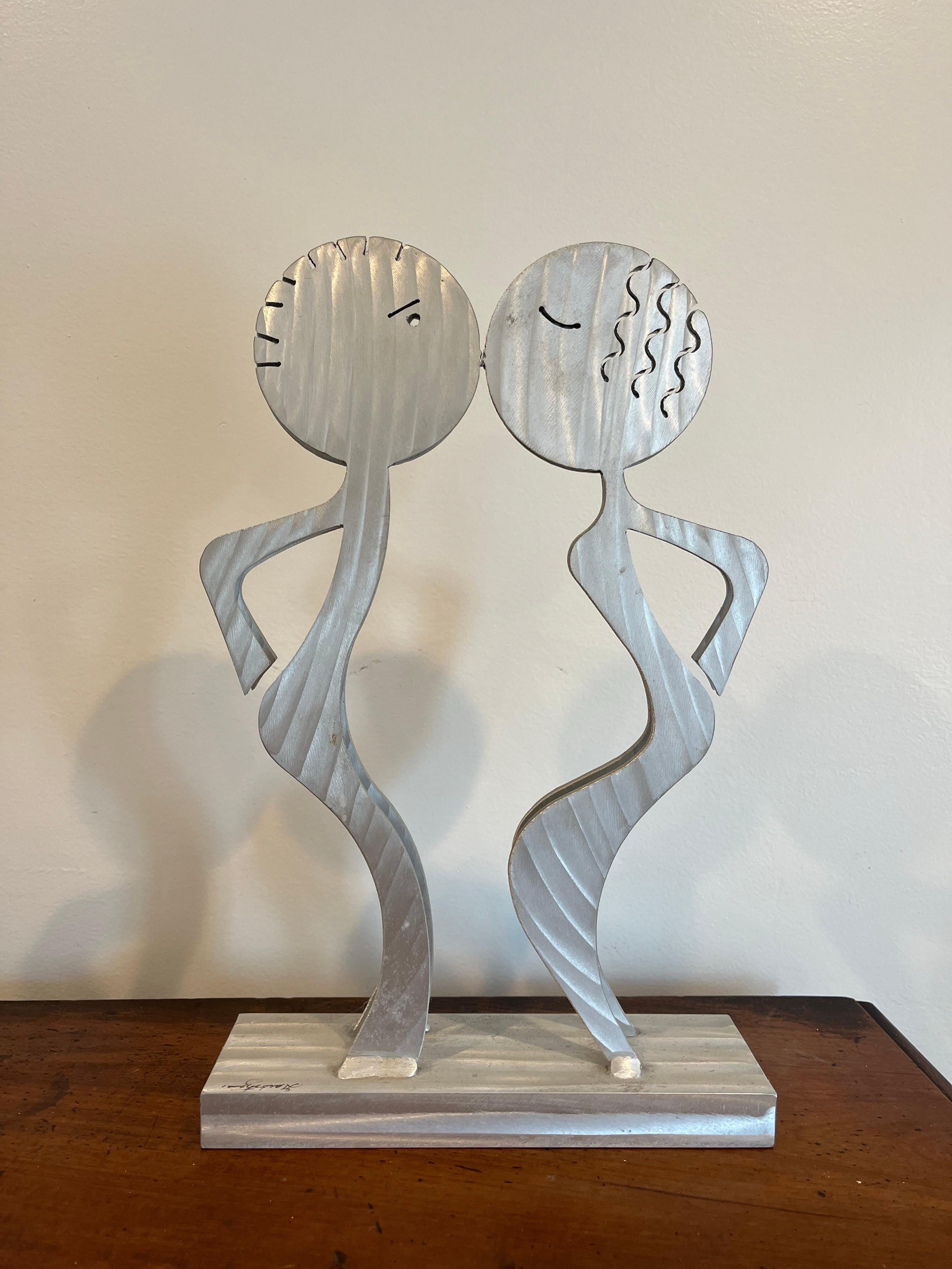 Rare postmodern figural sculpture of a kissing couple. Brushed aluminum signed and dated. Great whimsical postmodern design with a slim profile. Figure reflects styling of Keith Haring.