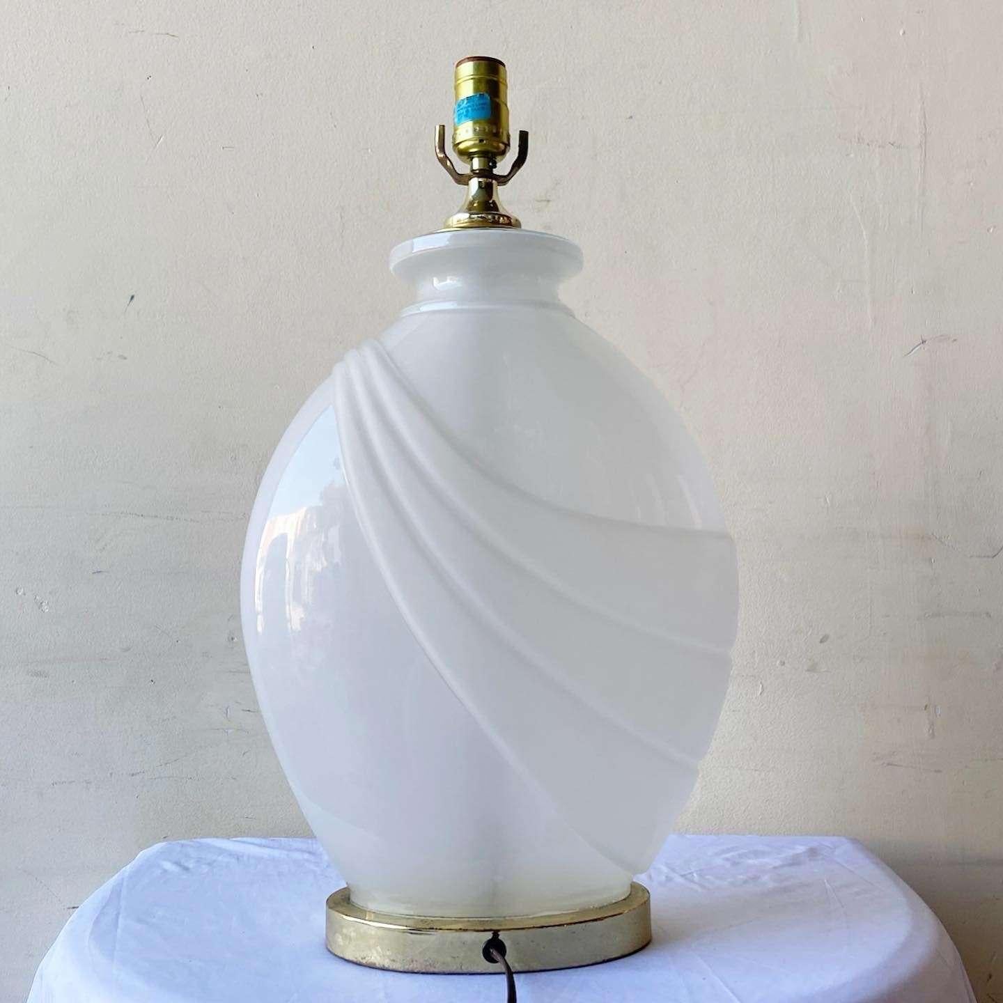 Exceptional vintage 1980s postmodern table lamp. Features a frosted glass on a gold base.

