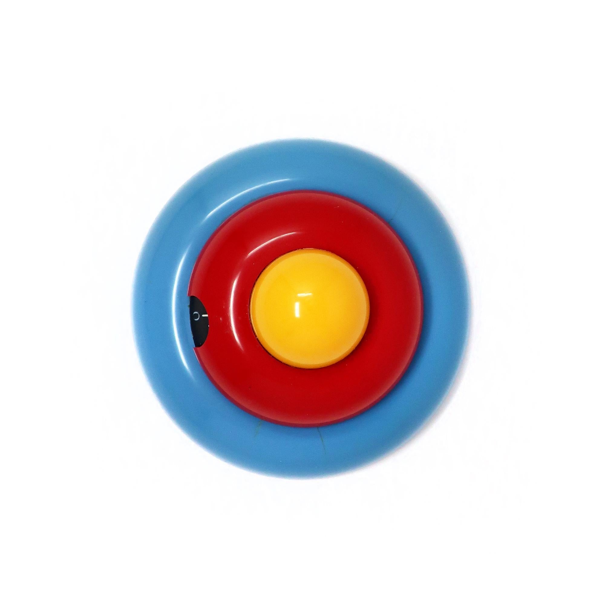 A whimsical Italian postmodern multicolor kitchen timer designed by Roberto Pezzetta for WikiDue.  Stacked light blue, red and yellow discs give it a fun Memphis Milano-inspried take on an egg in a pan.  Runs for up to 60 minutes.

In good vintage