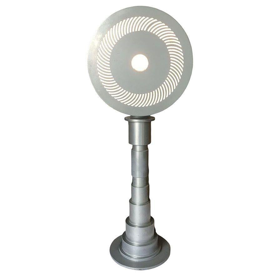Post-Modern Futurist Computer Age enameled metal table lamp featuring a metal drum shade with over 180 cut-outs fixed to a large machine part base. This lamp is a great example of Y2K futurism and would look great in any late 1990s or early