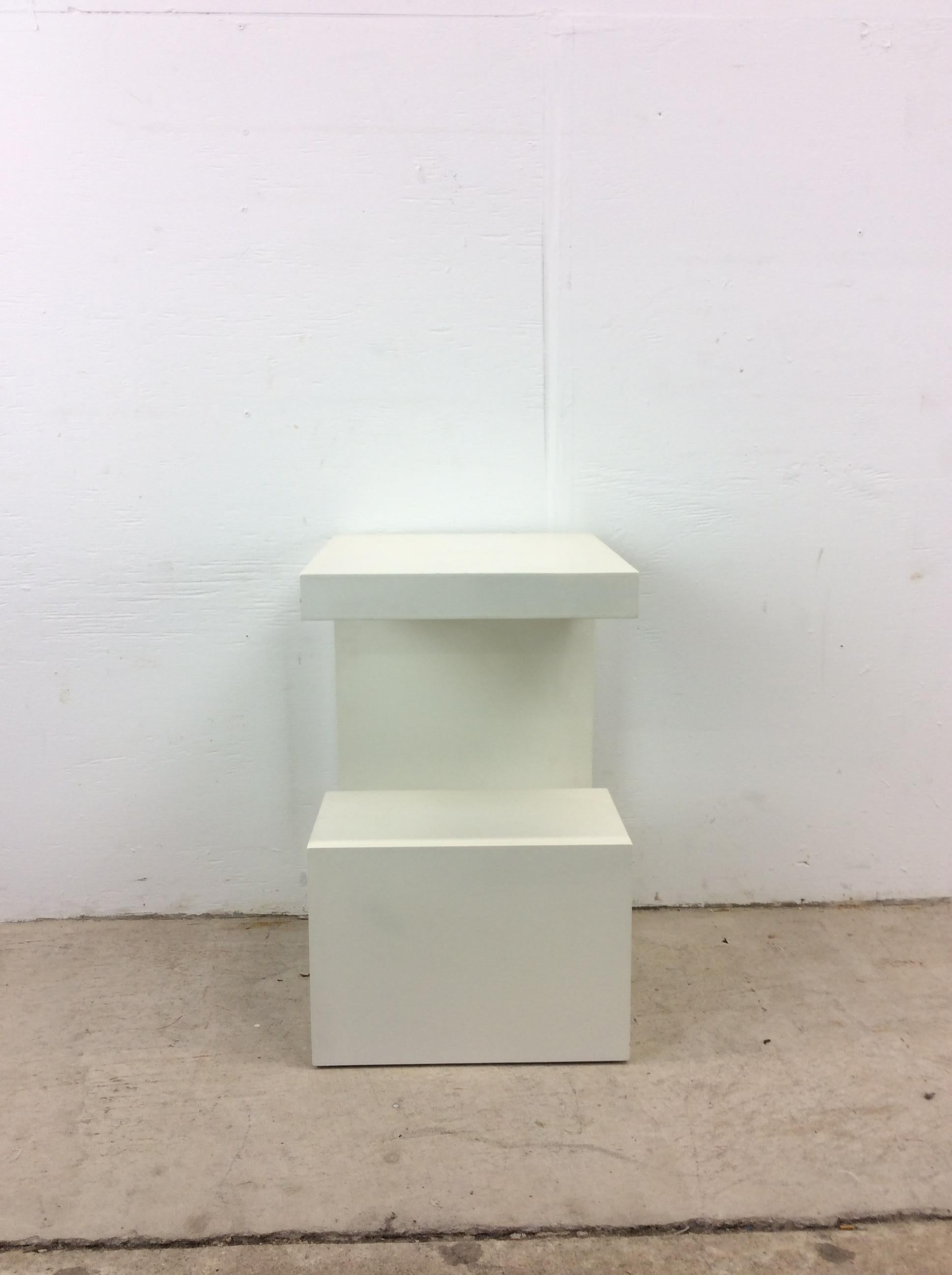 This post modern decorative pedestal features unique G shaped design offering multiple surfaces for displaying curios and a white lacquer finish. 

Complimentary white lacquer pedestal available separately.

Dimensions: 14w 16d 22h

Condition: