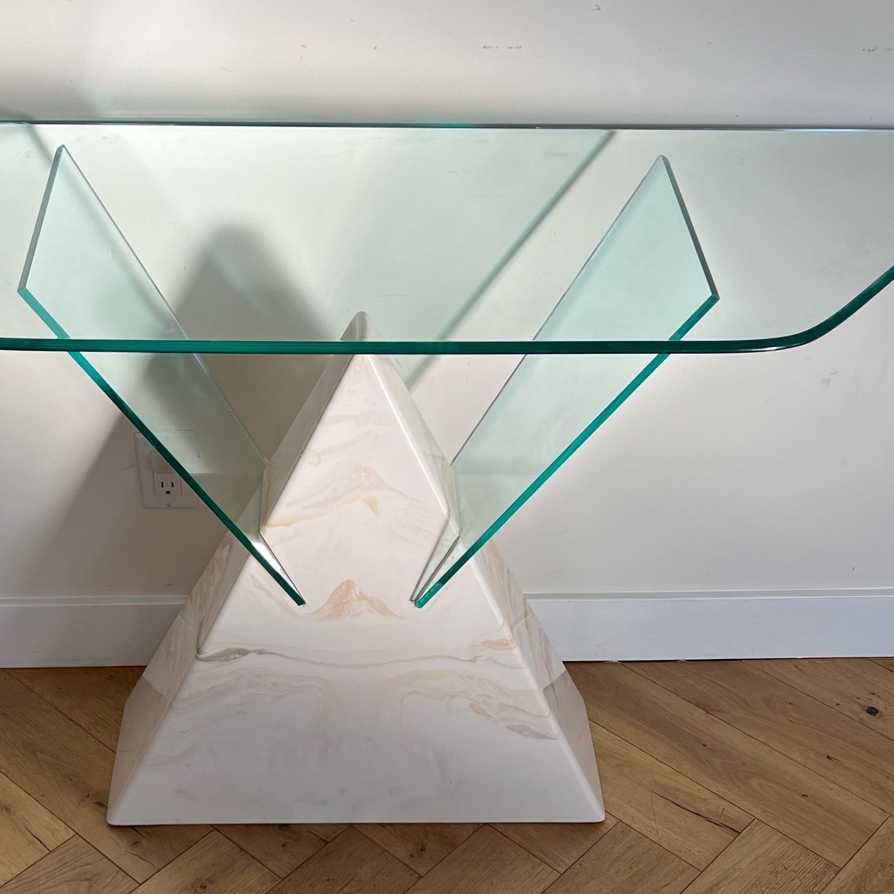 A postmodern triangular console table of faux marble and glass, late 1970s. Spectacular geometry. Base is believed to be a mixture of cement and plaster with a marbled coating in tones of ivory, ecru, and soft caramel. Minor signs of age (truly