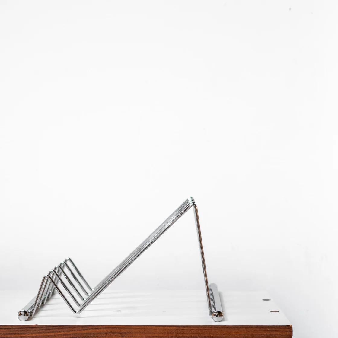 A sleek postmodern stand from France, originally designed for tableware but versatile enough to use as a book or display stand. Its clean geometric lines and lightweight metal construction make it a functional accent for kitchen, workspace, or