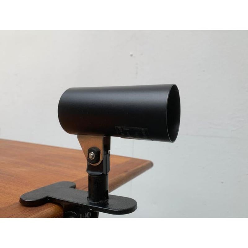Lámpara de pinza minimalista de erco.

Un diseño funcional. La luminaria consiste en un simple tubo que oculta la toma. La cabeza puede alinearse con una articulación. La pinza grande es de plástico negro. La pinza permite una apertura de hasta 4