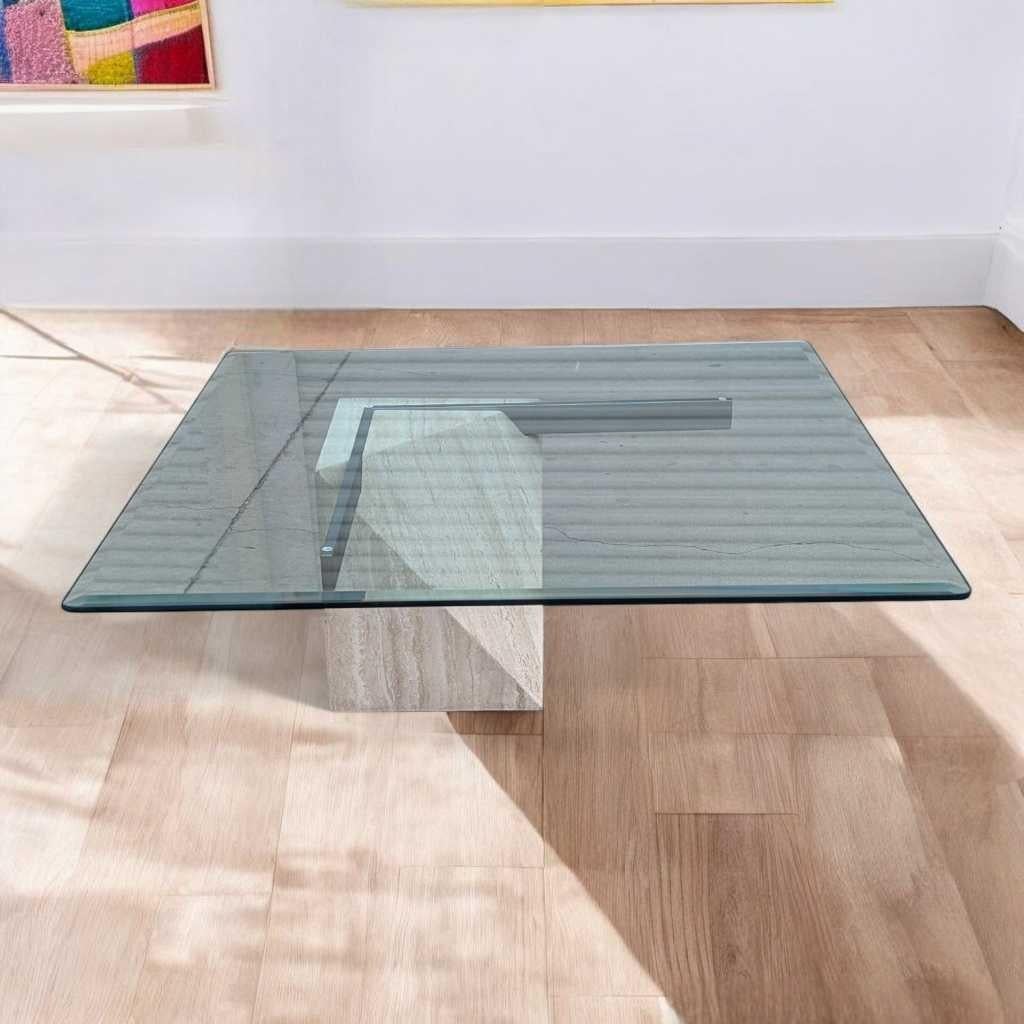 A distinctive vintage coffee table, crafted from a square glass top and a travertine pedestal base with silver-finished metal cross bars. This piece blends minimalist geometry with sculptural form—ideal for a modern living room or creative