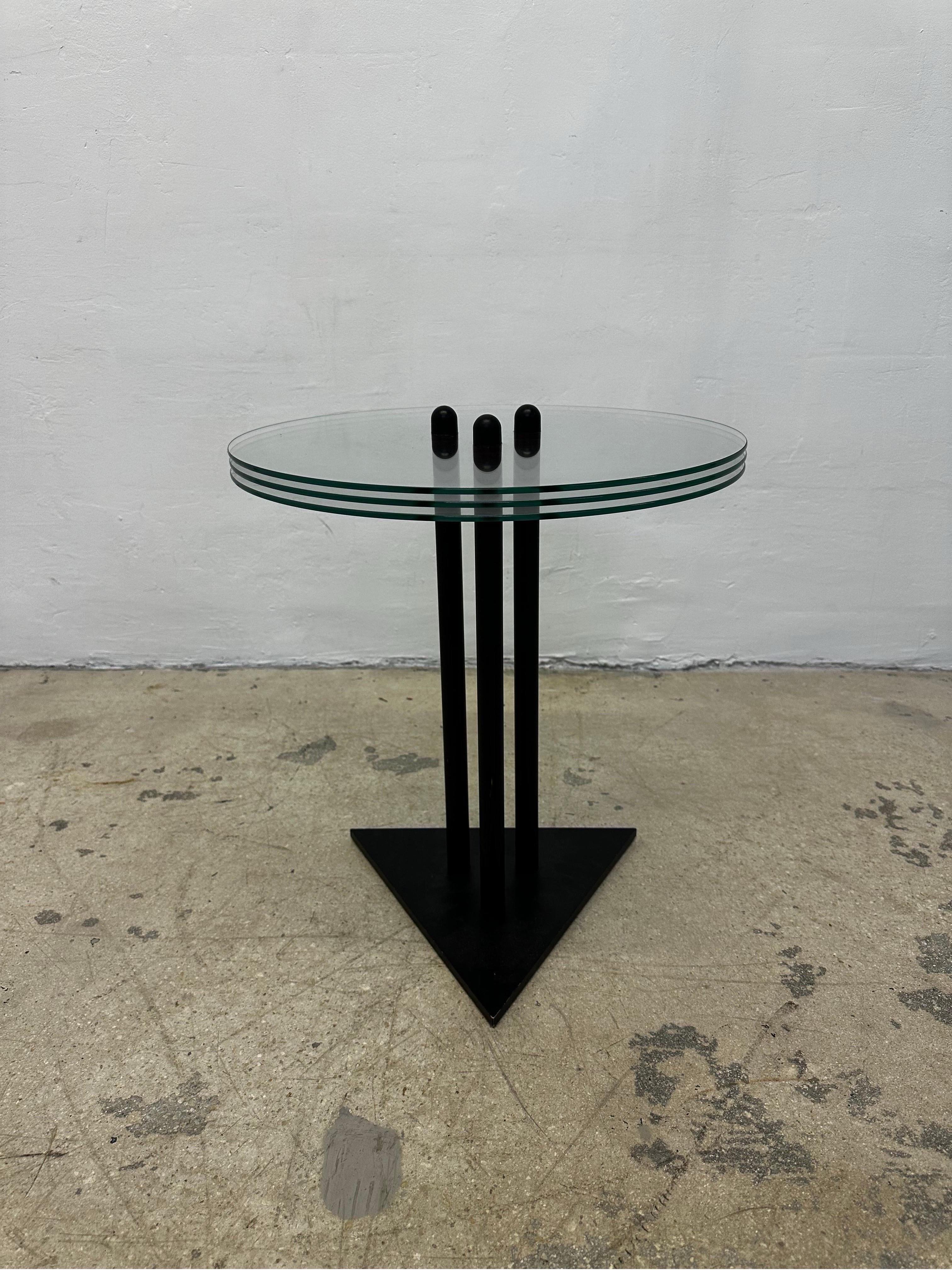 Postmodern black lacquered steel side or end table with three stacked pieces of glass designed and manufactured by Becker Designs USA circa 1990s.

Height to top of glass 19-5/8”.
