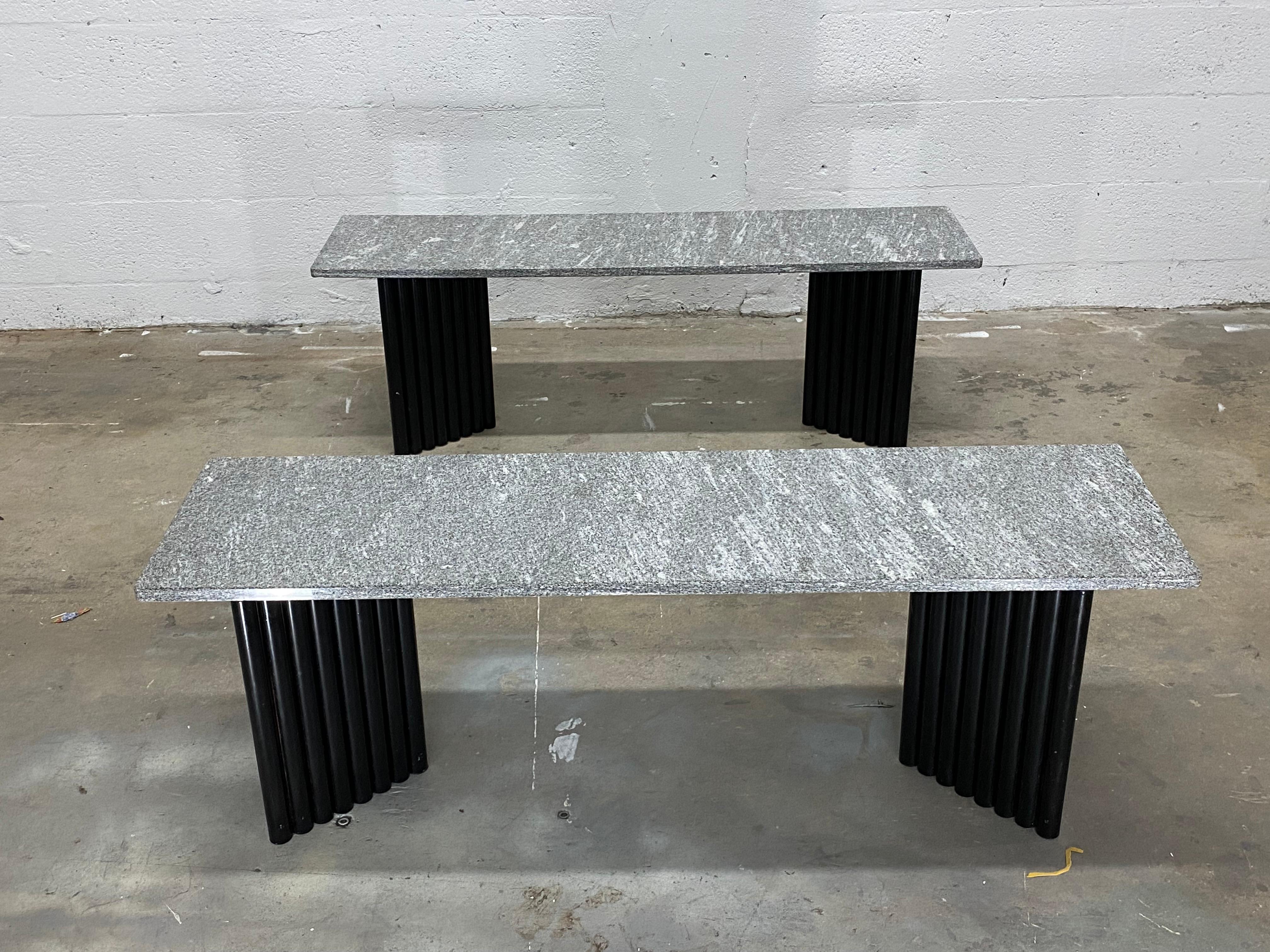 Pair of postmodern black powder-coated V-shaped tubular steel base tables with solid granite marble tops from the 1980s. Can be arranged in a multitude of variations: side tables, coffee tables, or stacking shelves.

Each table measures:
W 13