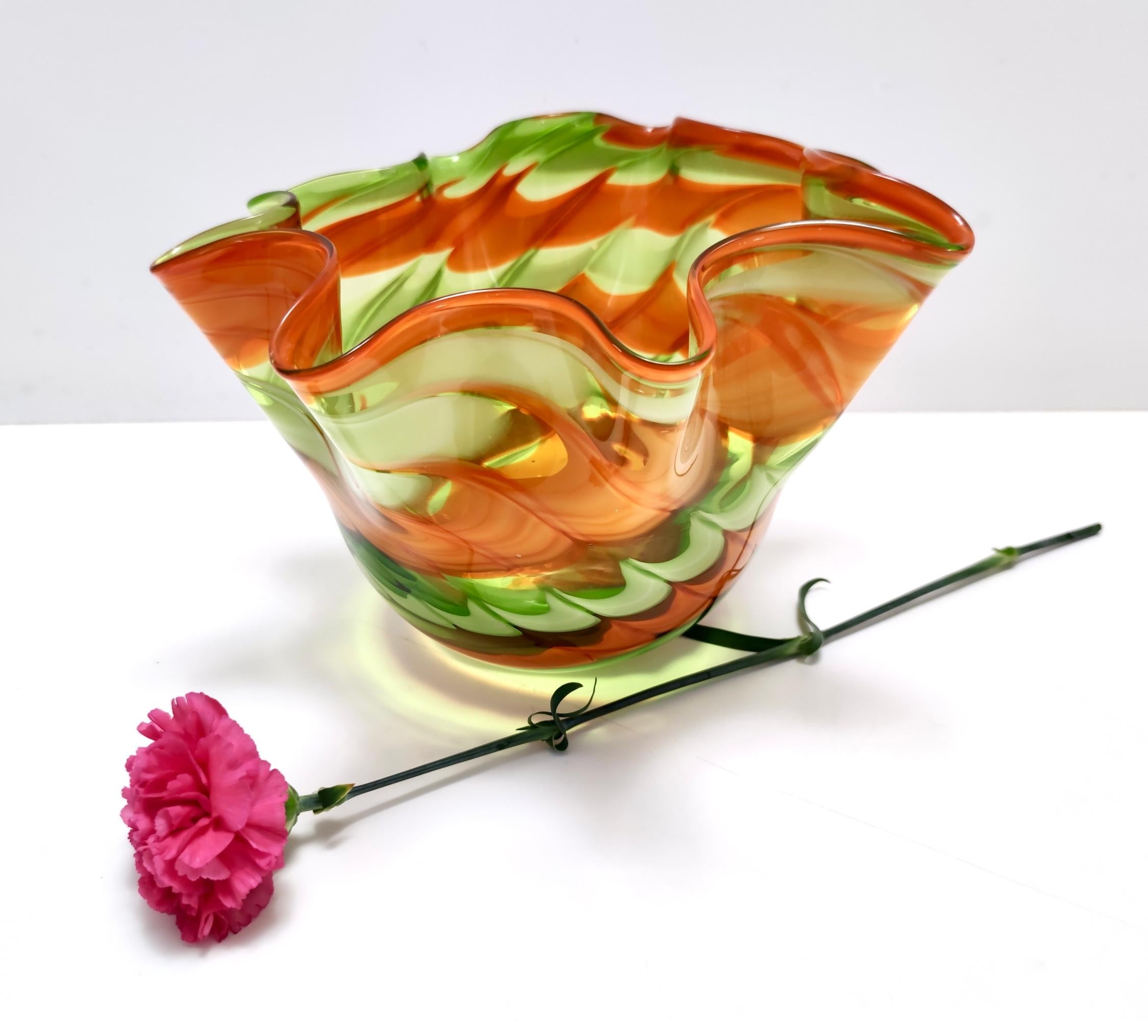 Hergestellt in Italien, 1980er Jahre. 
Dies ist eine Vase aus Murano-Glas von Fratelli Toso mit grünen und orangefarbenen Pinselstrichen.
Da es sich um ein Vintage-Stück handelt, kann es leichte Gebrauchsspuren aufweisen, aber es ist in perfektem