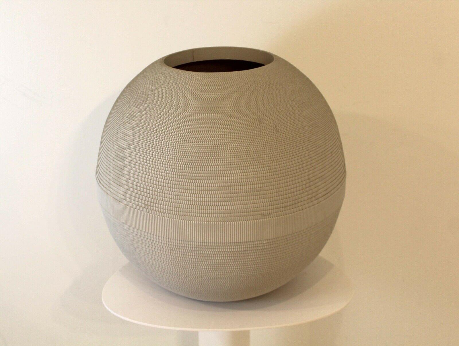 From Le Shoppe Too in Michigan, this large corrugated cardboard vase rendered in matte gray by Flute, Chicago circa 1980s and moving in concentric circles creating the round shape. In very good condition with little or no